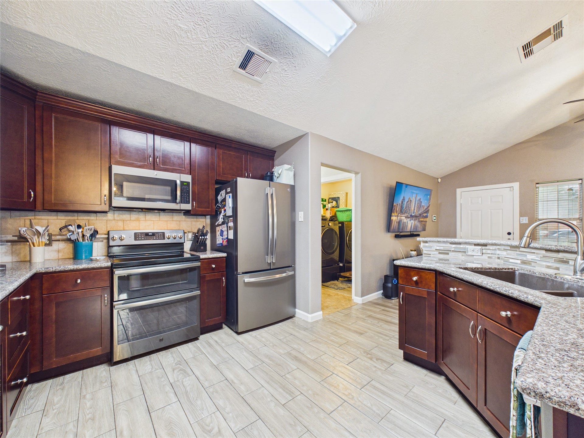 9022 Barracuda Drive, Texas City, TX 77591 The kitchen is functional, featuring granite countertops, stainless steel appliances, and tile flooring.