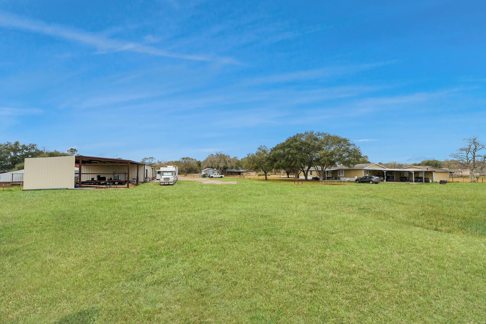 17115 County Road 831, Pearland, TX 77584 View from the pond showing the shop and 2400 sq ft 4/3/2 manufactured home with huge, covered patio.