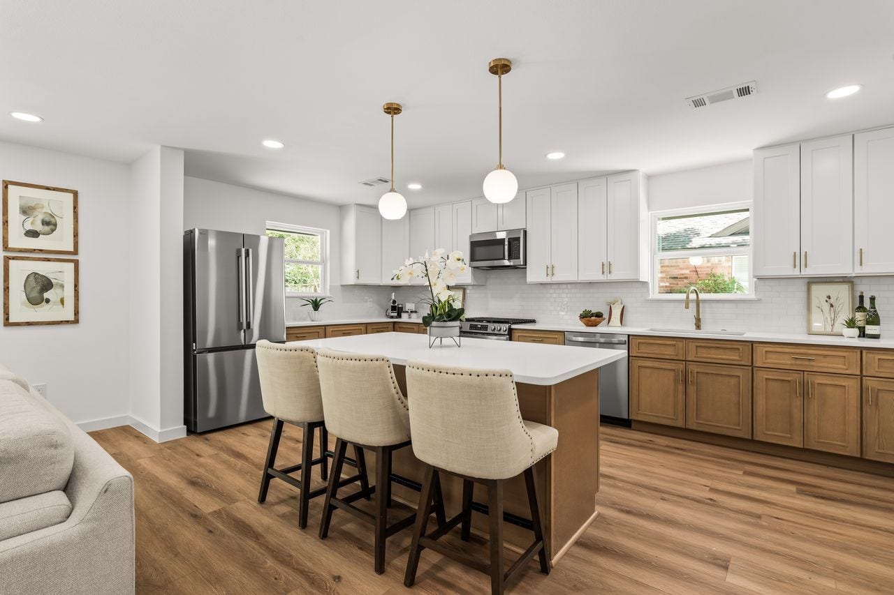 5207 Hummingbird Street, Houston, TX 77035 Renovated kitchen featuring two/tone cabinetry, quartz countertops, stainless steel appliances and modern brass accents