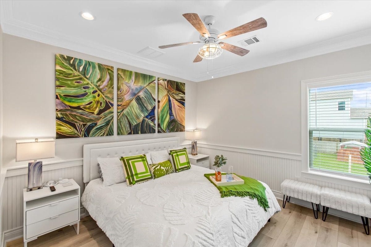 3211 Avenue K, Galveston, TX 77550 Fist floor primary bedroom with king sized bed. The artwork and accent pieces highlight the room so well!