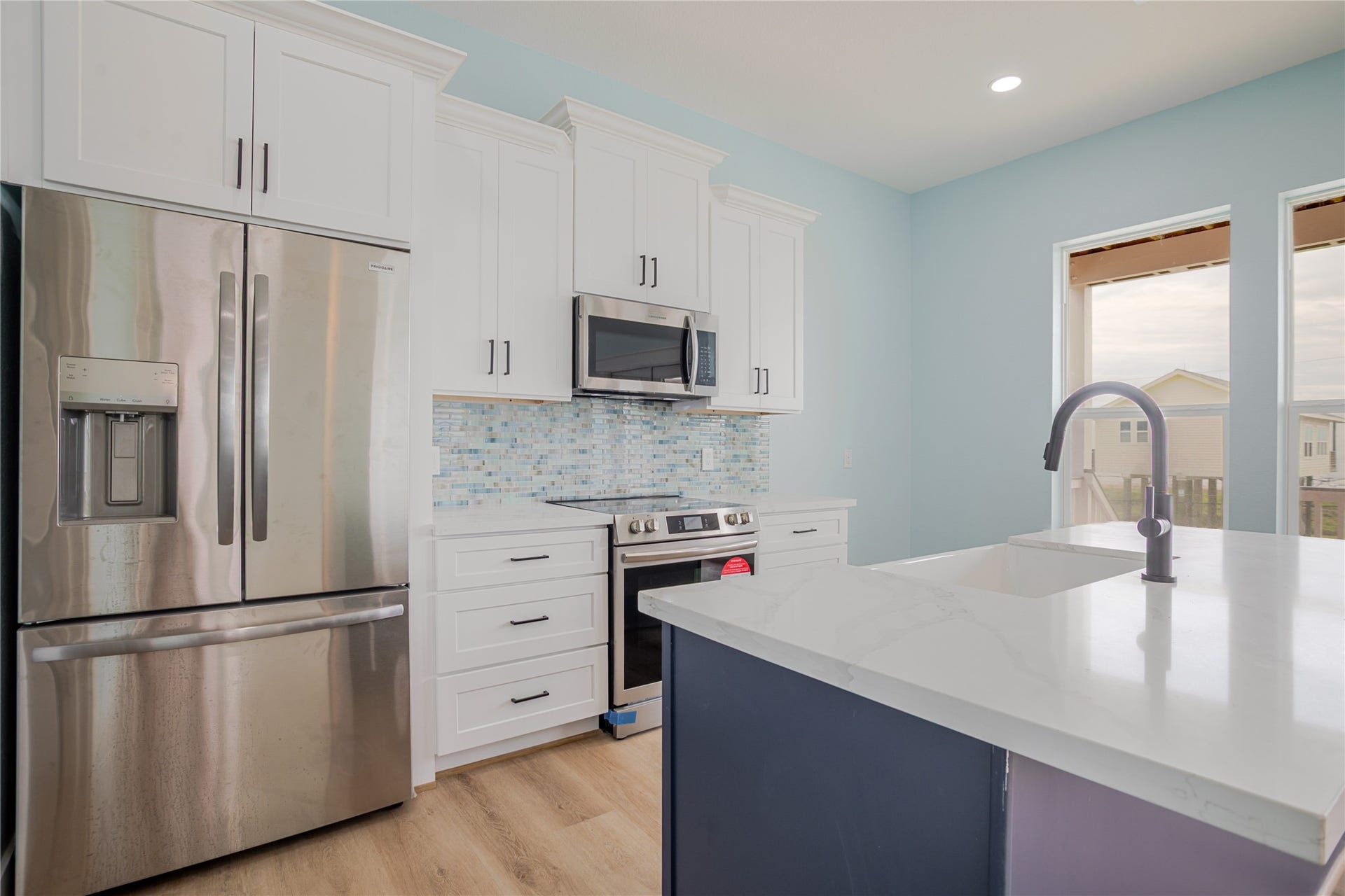17518 Bristow Drive, Galveston, TX 77554 Soft colors in kitchen with white cabinets and modern navy color accent on the large island