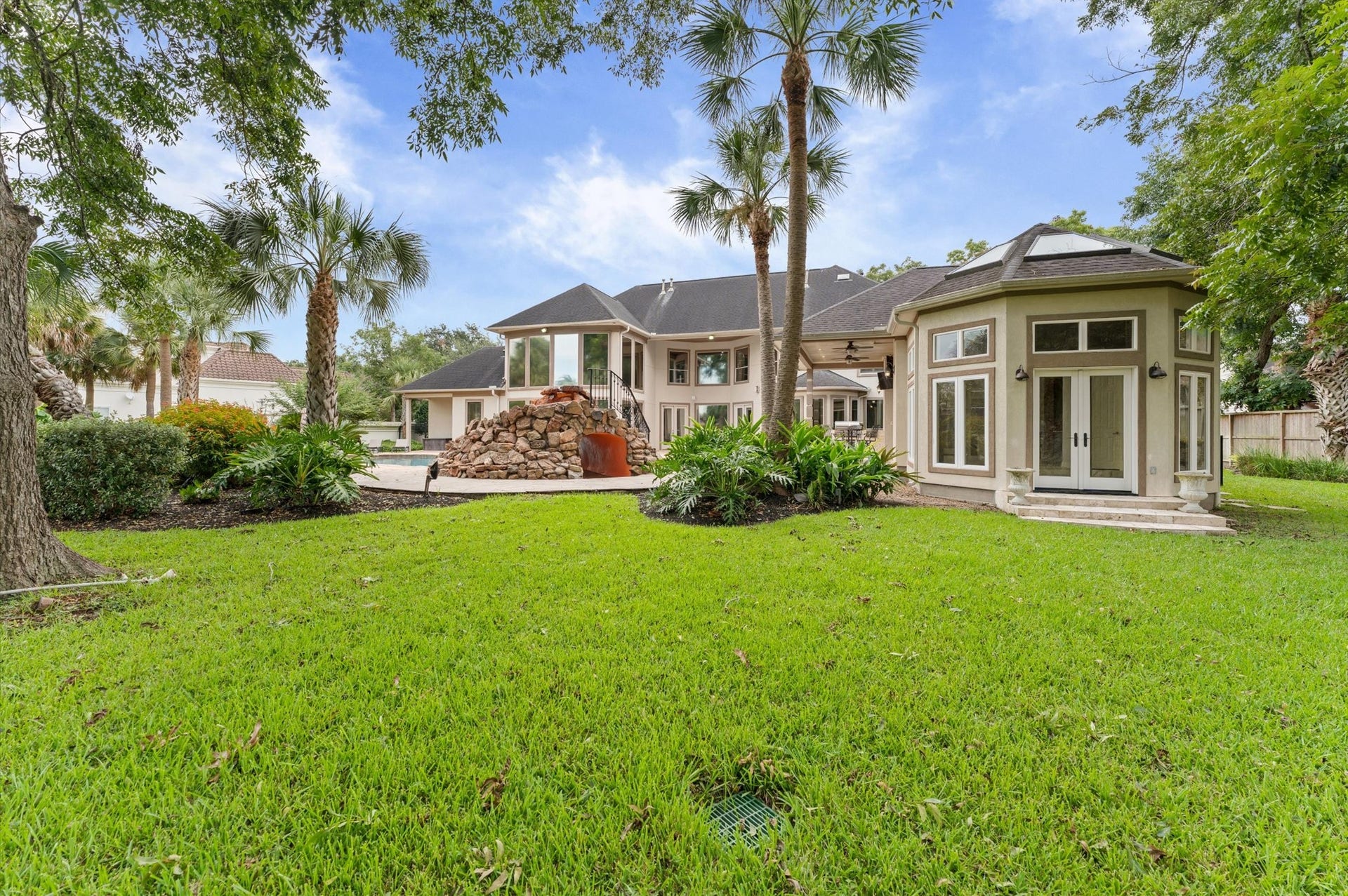 1830 Forest Gate Circle, Sugar Land, TX 77479 This view of your home shows beautiful St. Augustine grass, several palm trees and the door on the right leads you into the sunroom of the cabana.