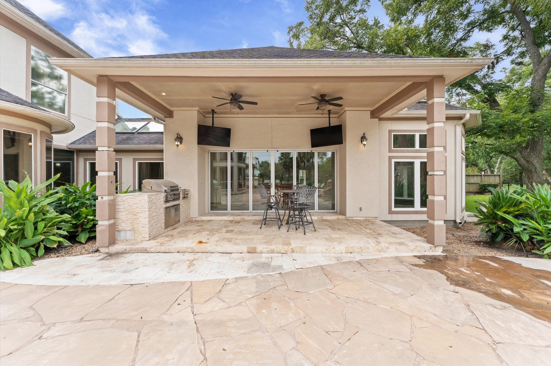 1830 Forest Gate Circle, Sugar Land, TX 77479 This is a view of the outdoor kitchen and into the cabana. Notice the double fans and TV's.