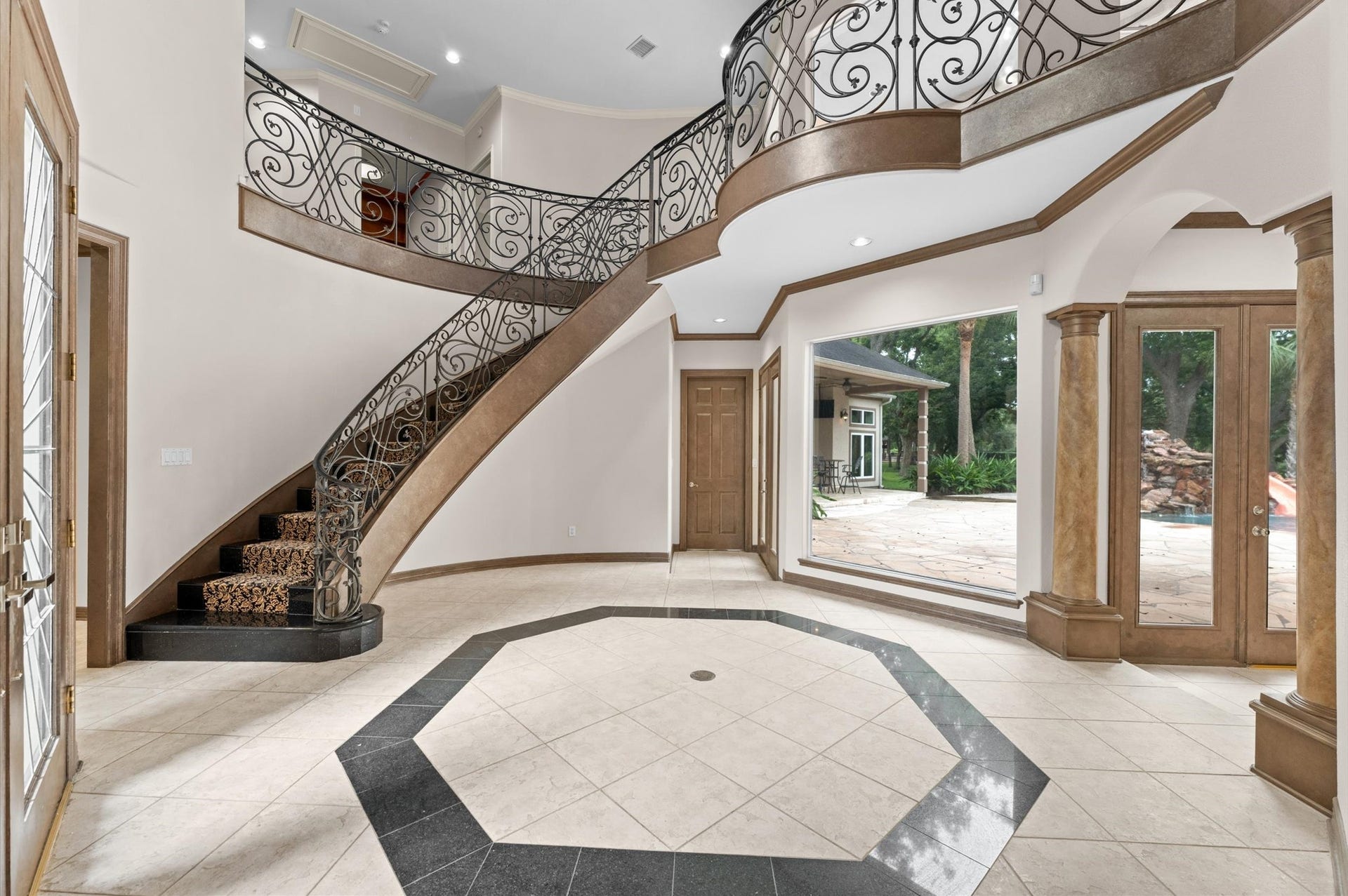 1830 Forest Gate Circle, Sugar Land, TX 77479 This grand foyer is a showstopper! 2-story, customized stair railing, the wall of windows looking into the backyard oasis.