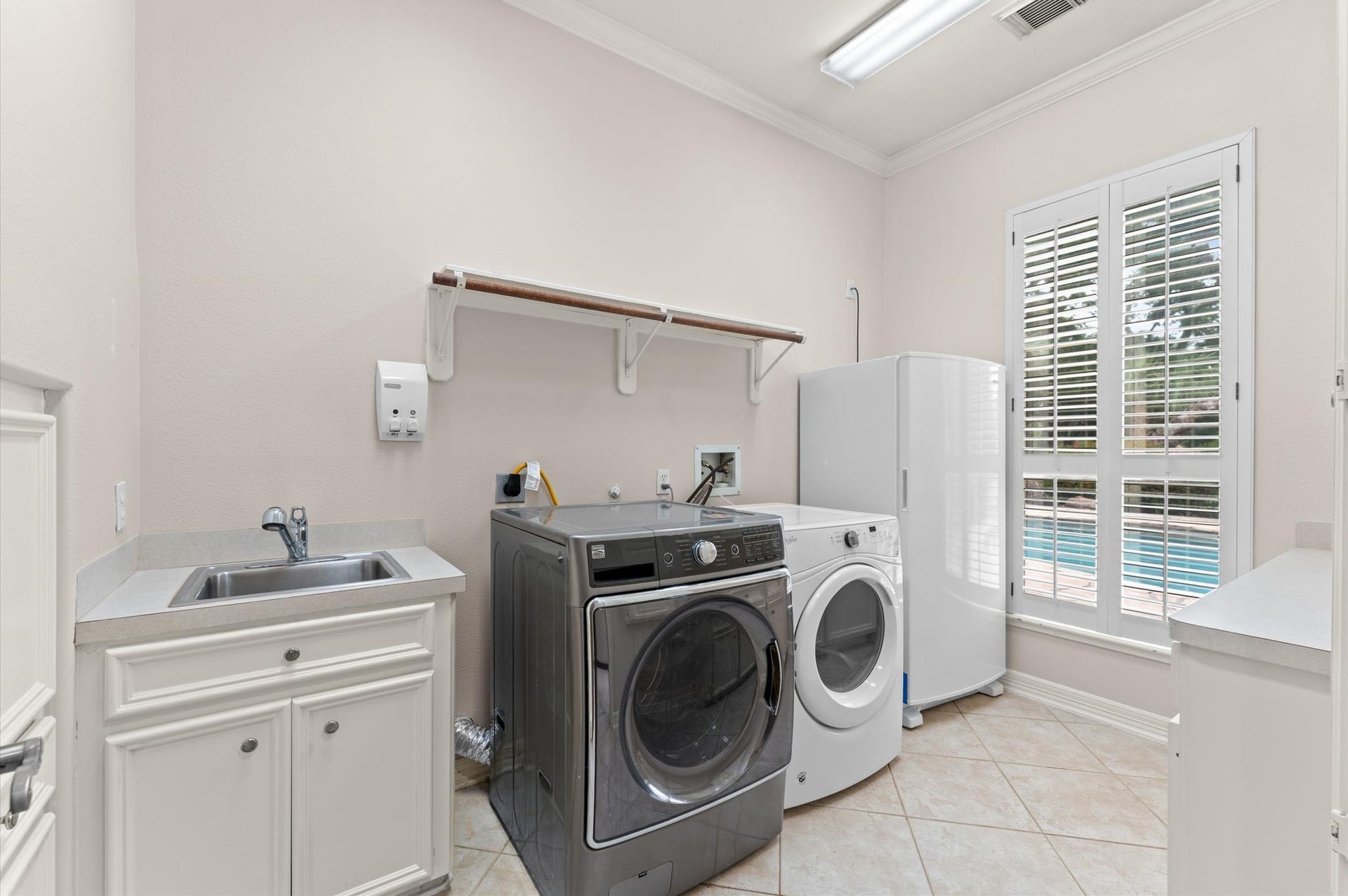 1830 Forest Gate Circle, Sugar Land, TX 77479 The laundry has: a sink, room for oversized washer & dryer, deep freeze, built-in cabinets, counter space for folding, built-in iron and a view of the pool!