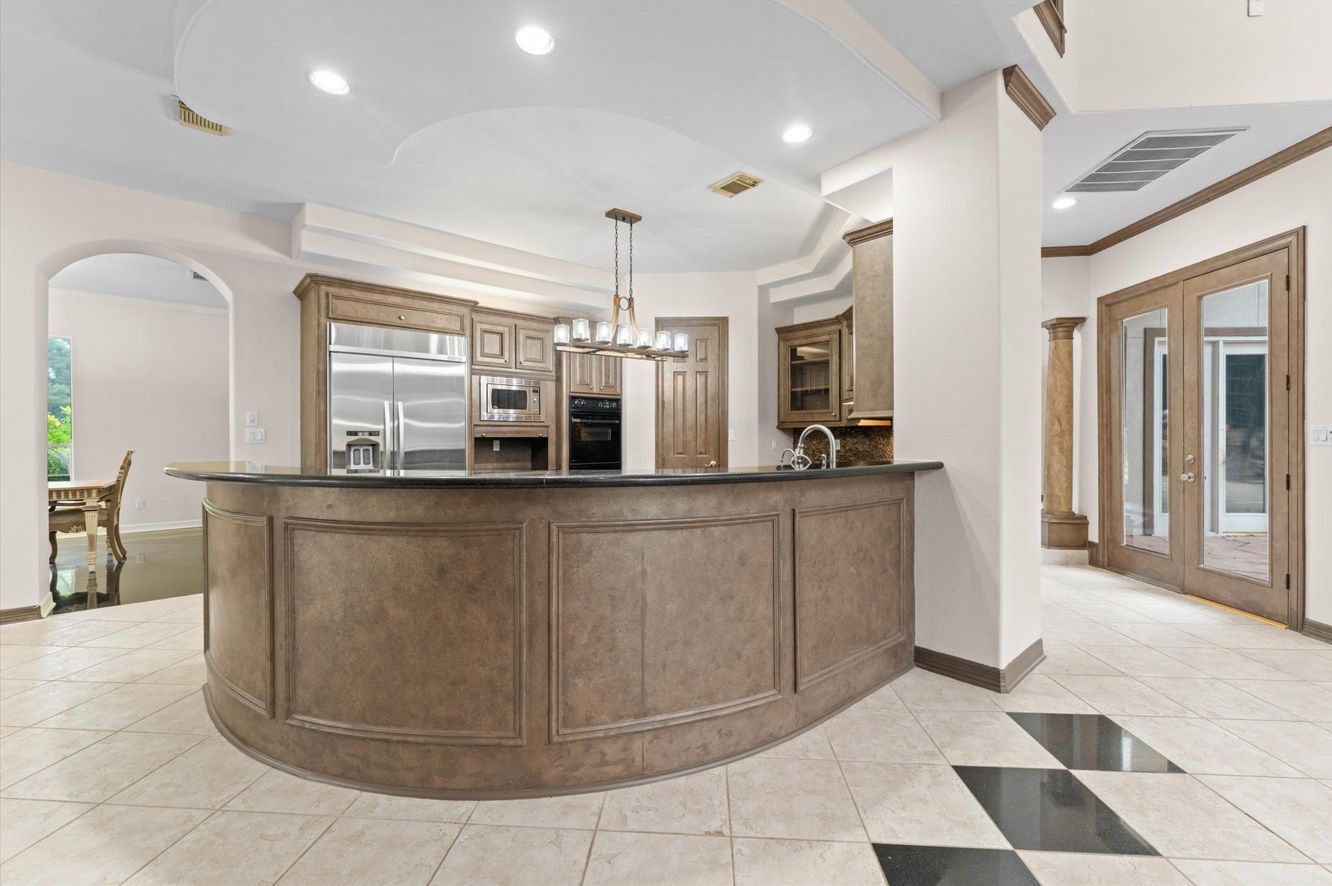 1830 Forest Gate Circle, Sugar Land, TX 77479 A view into the kitchen that is open to the breakfast area shows a large circular breakfast bar.