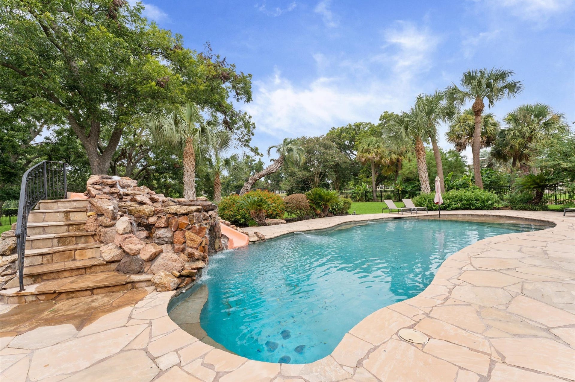 1830 Forest Gate Circle, Sugar Land, TX 77479 This pool is stunning, has a water slide with waterfall and under rocks is your very own grotto! The foliage around the pool and throughout the yard provides a tropical feeling as if you are always on vacation at home!