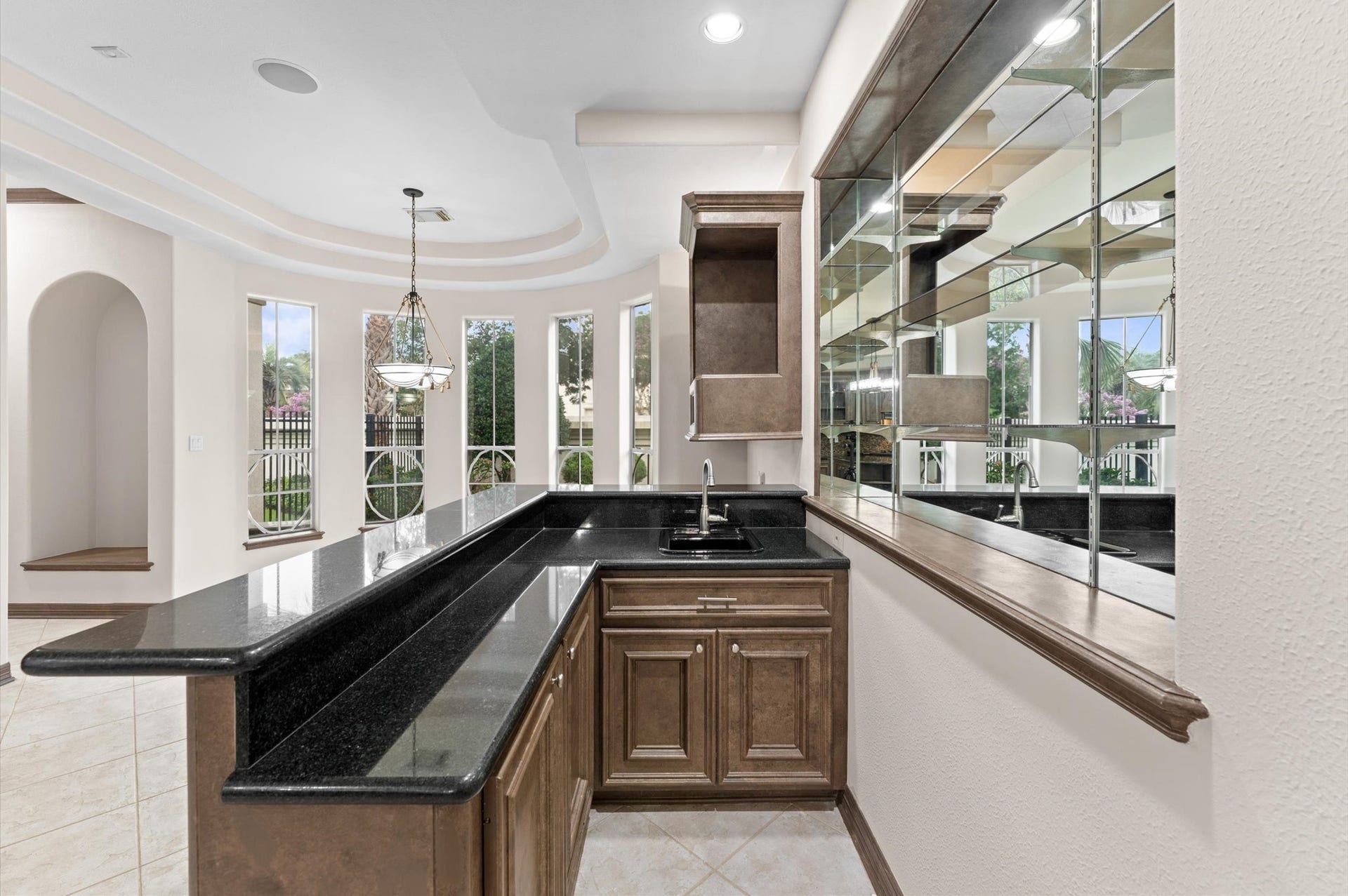 1830 Forest Gate Circle, Sugar Land, TX 77479 A view of the wet bar which offers plenty of space for bar stools, a mirror wall where your many liquors are displayed. The breakfast room sits by the windows which is the perfect place to start your day!