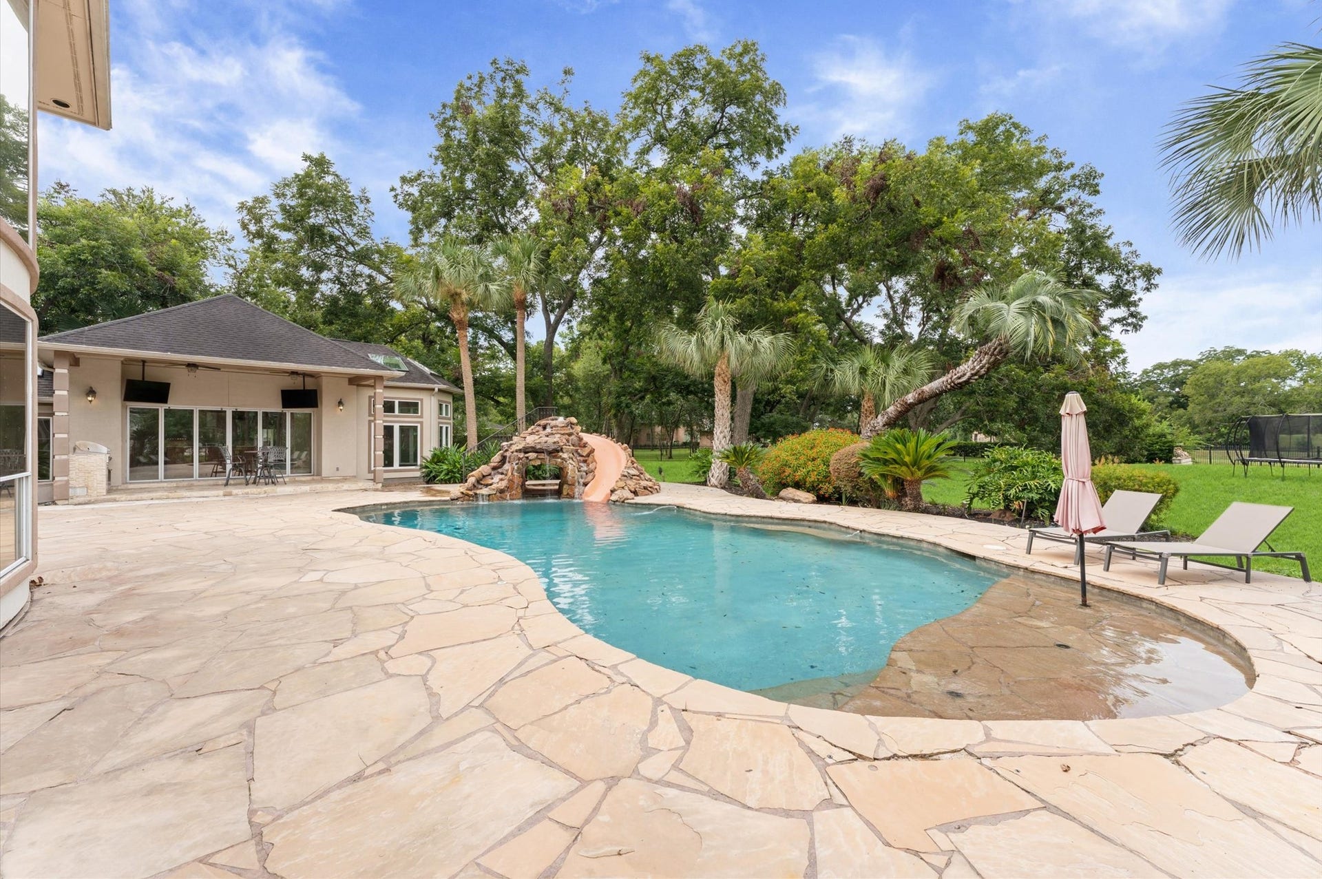 1830 Forest Gate Circle, Sugar Land, TX 77479 Another view of the pool has a water shelf for sunning, offers a peak into the grotto and a luxurious yard.