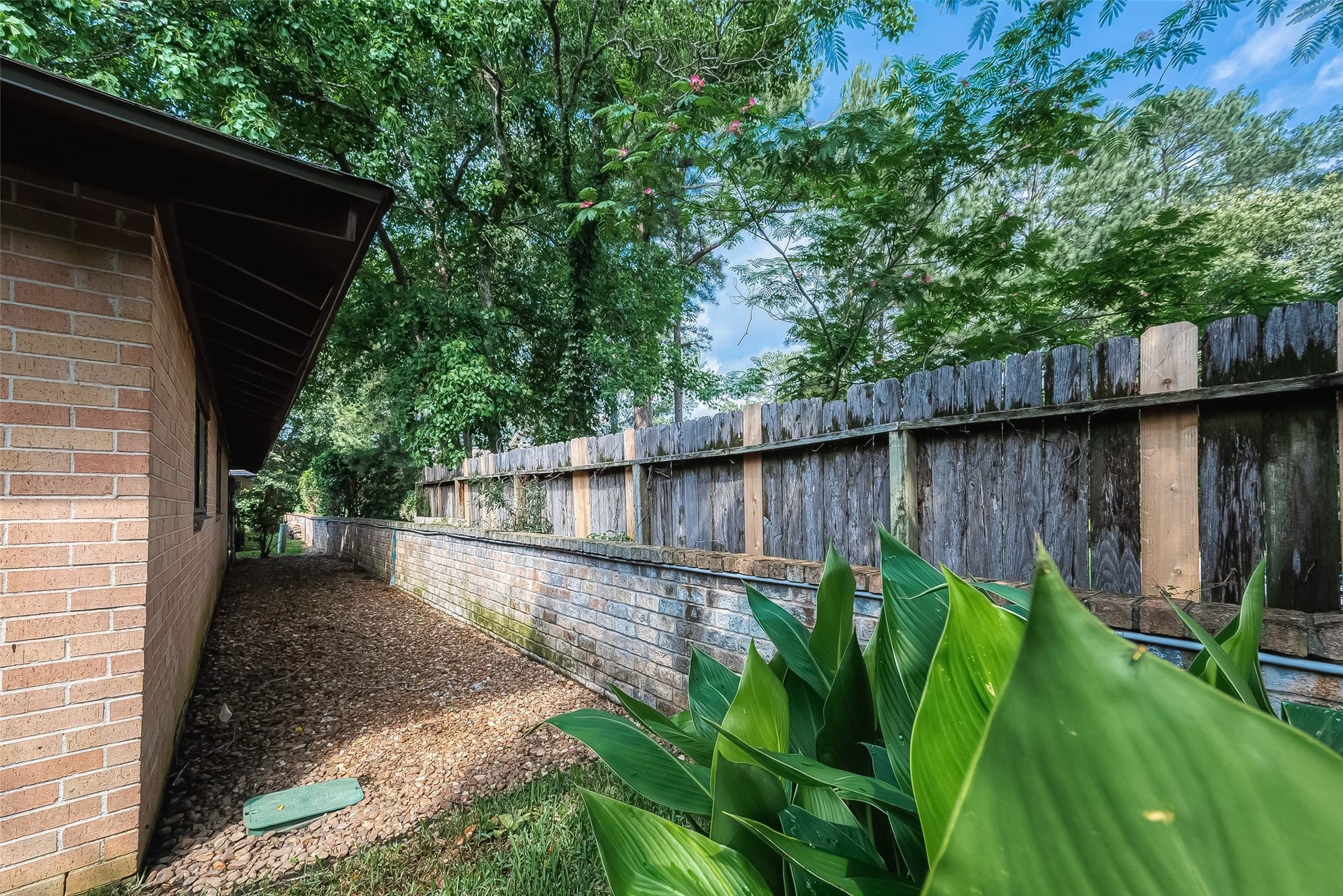 20 Champions Colony E, Houston, TX 77069 A backyard enclosed by a combination of brick and wood fencing offers both aesthetic appeal and practical functionality.