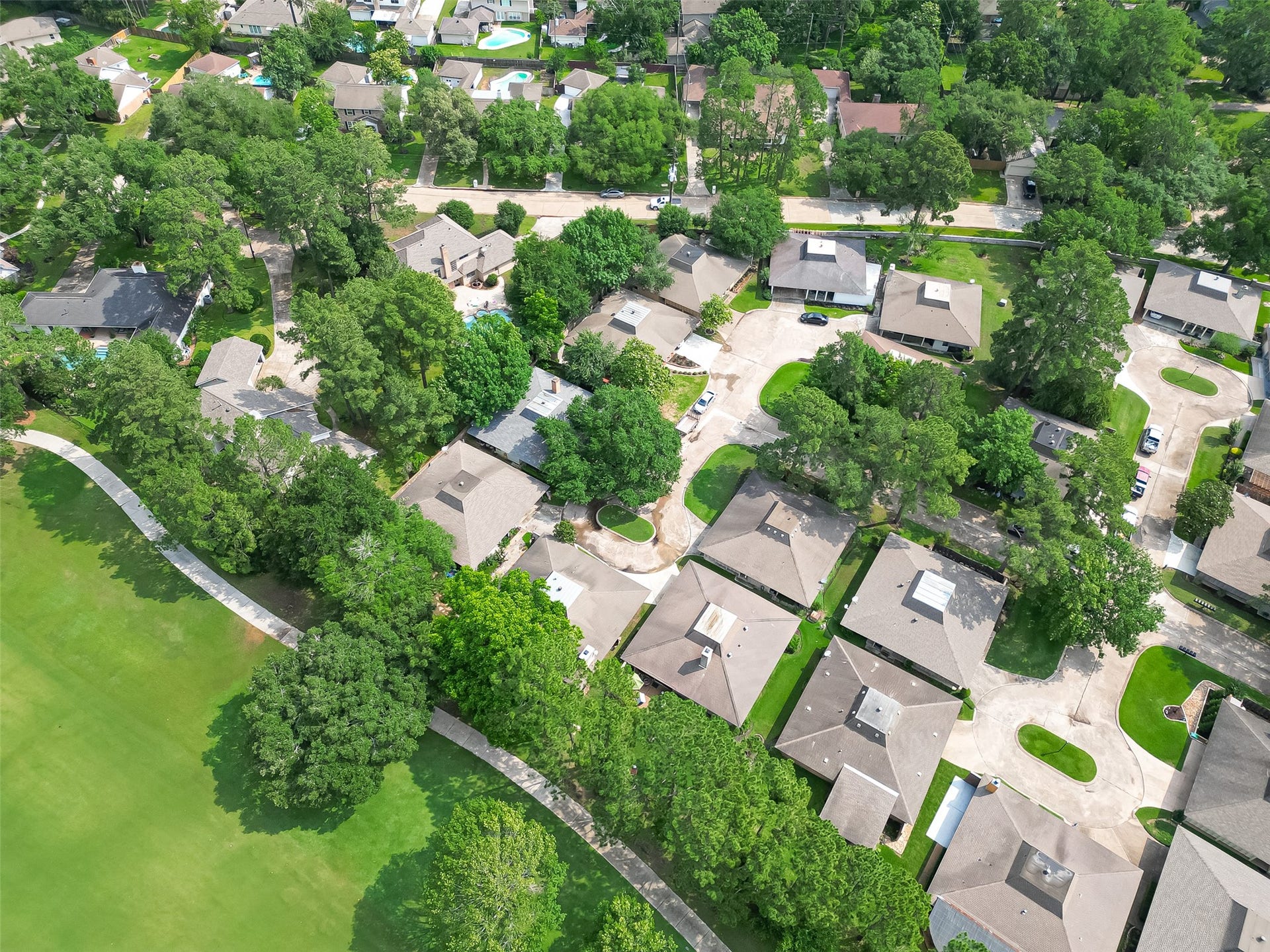 20 Champions Colony E, Houston, TX 77069 This aerial perspective captures the essence of tranquility and community, showcasing the verdant landscapes and architectural charm that define this esteemed enclave. With each rooftop a testament to the unique character of its residence, this view offers a glimpse into the serene beauty and harmonious living that await within Champion Forest.