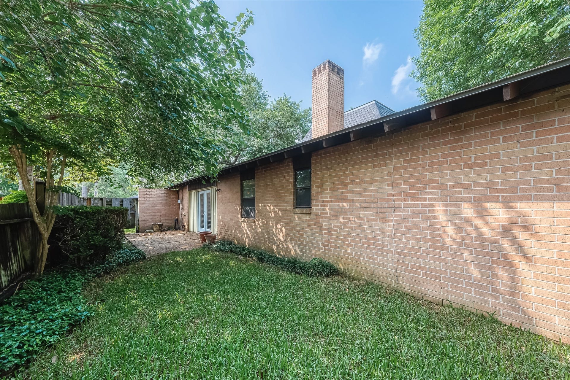 20 Champions Colony E, Houston, TX 77069 The lush foliage of trees and surrounding greenery provides a beautiful and calming backdrop for the side of the house. It adds a sense of tranquility and natural charm to the outdoor space.