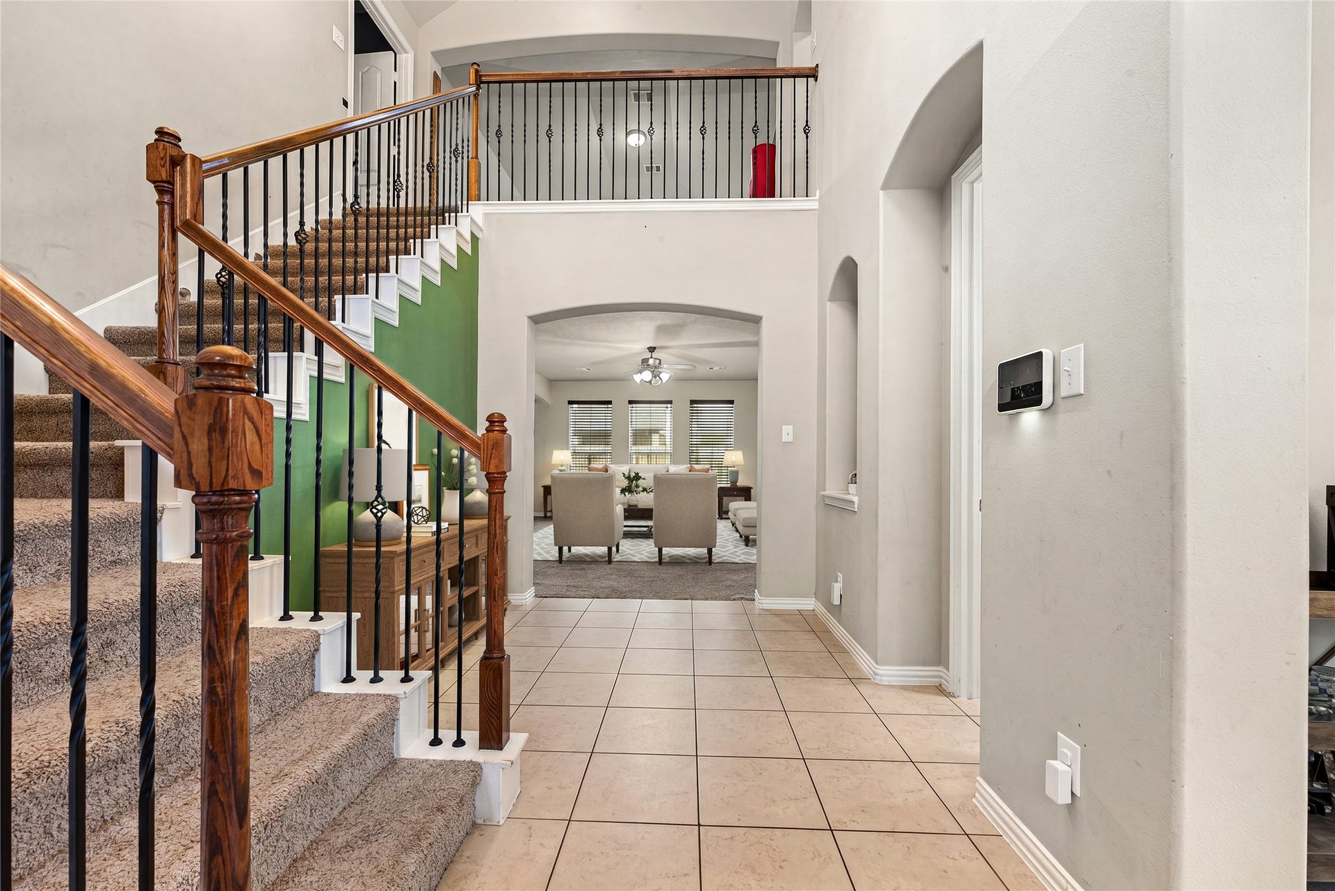 7018 Pearl Terrace Lane, Richmond, TX 77469 Step inside to a dramatic two-story entry featuring tile flooring, a handsome wood-and-iron staircase, and an arched opening that draws you into the sunlit formal living space. *Virtually Staged