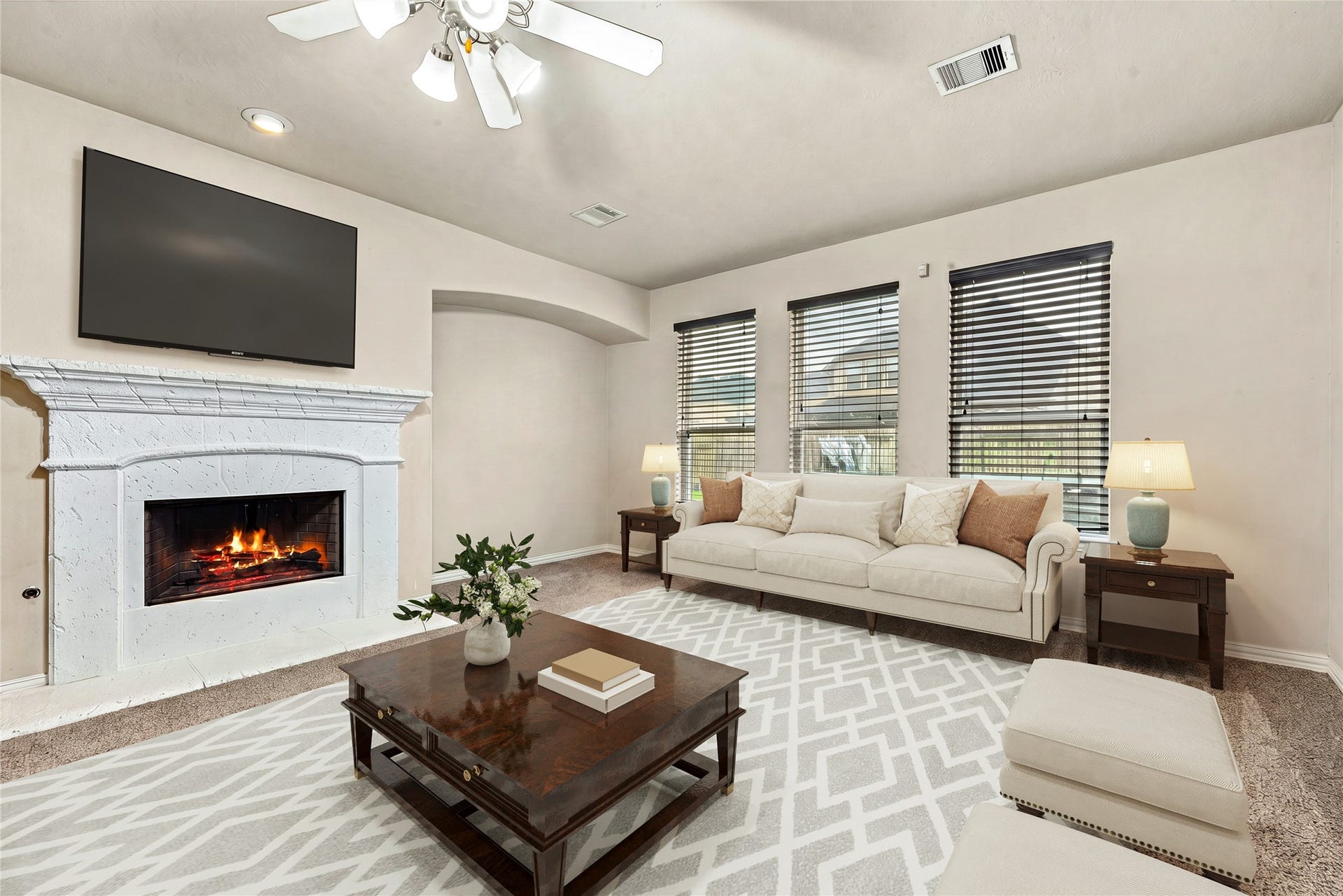 7018 Pearl Terrace Lane, Richmond, TX 77469 Warm and inviting family room featuring a classic fireplace, an arched accent niche, and a wall of windows for plenty of natural light. *Virtually Staed