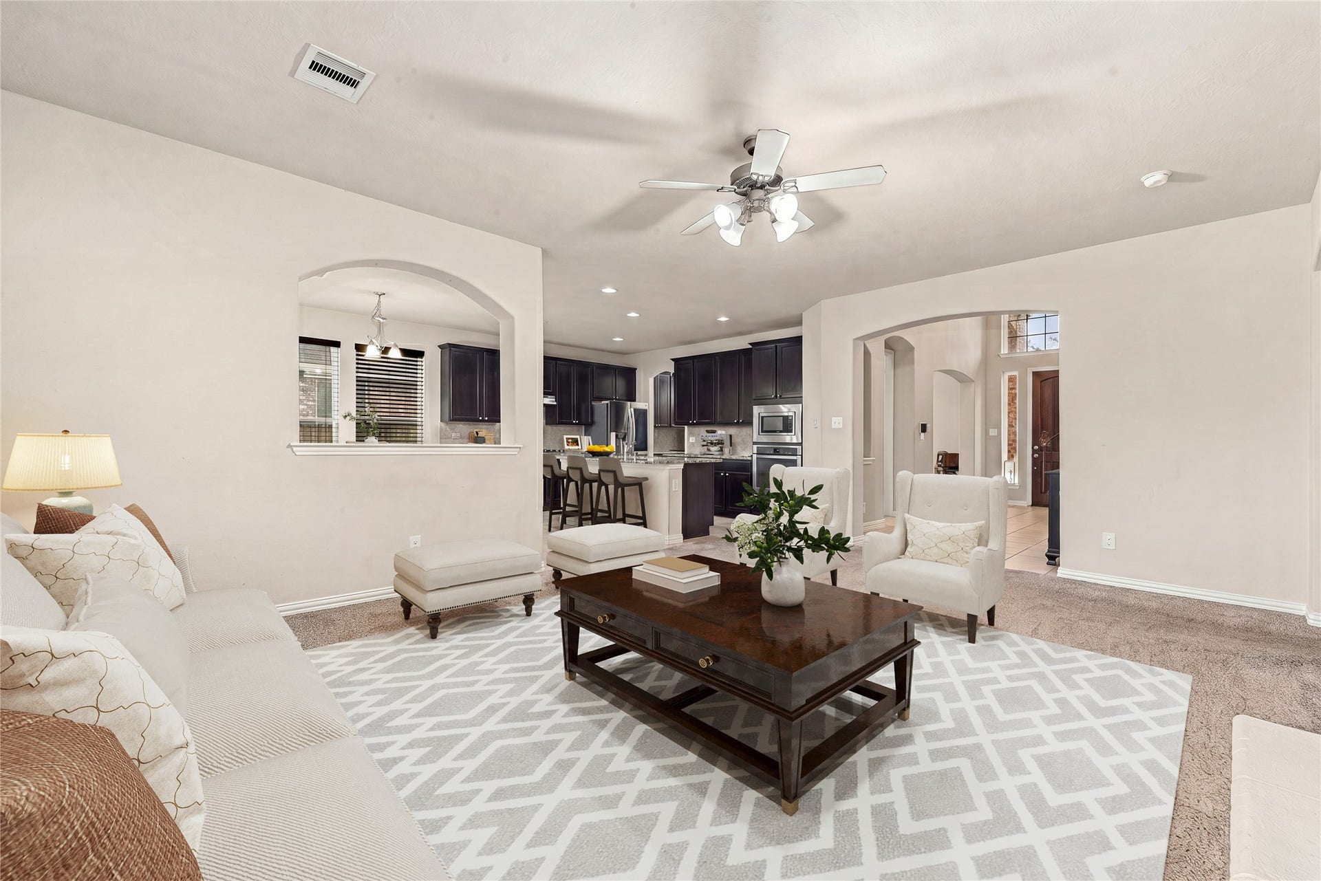 7018 Pearl Terrace Lane, Richmond, TX 77469 The open-concept living room flows seamlessly into the kitchen and breakfast area, with arched entryways and abundant natural light creating a bright, connected space. *Virtually Staged