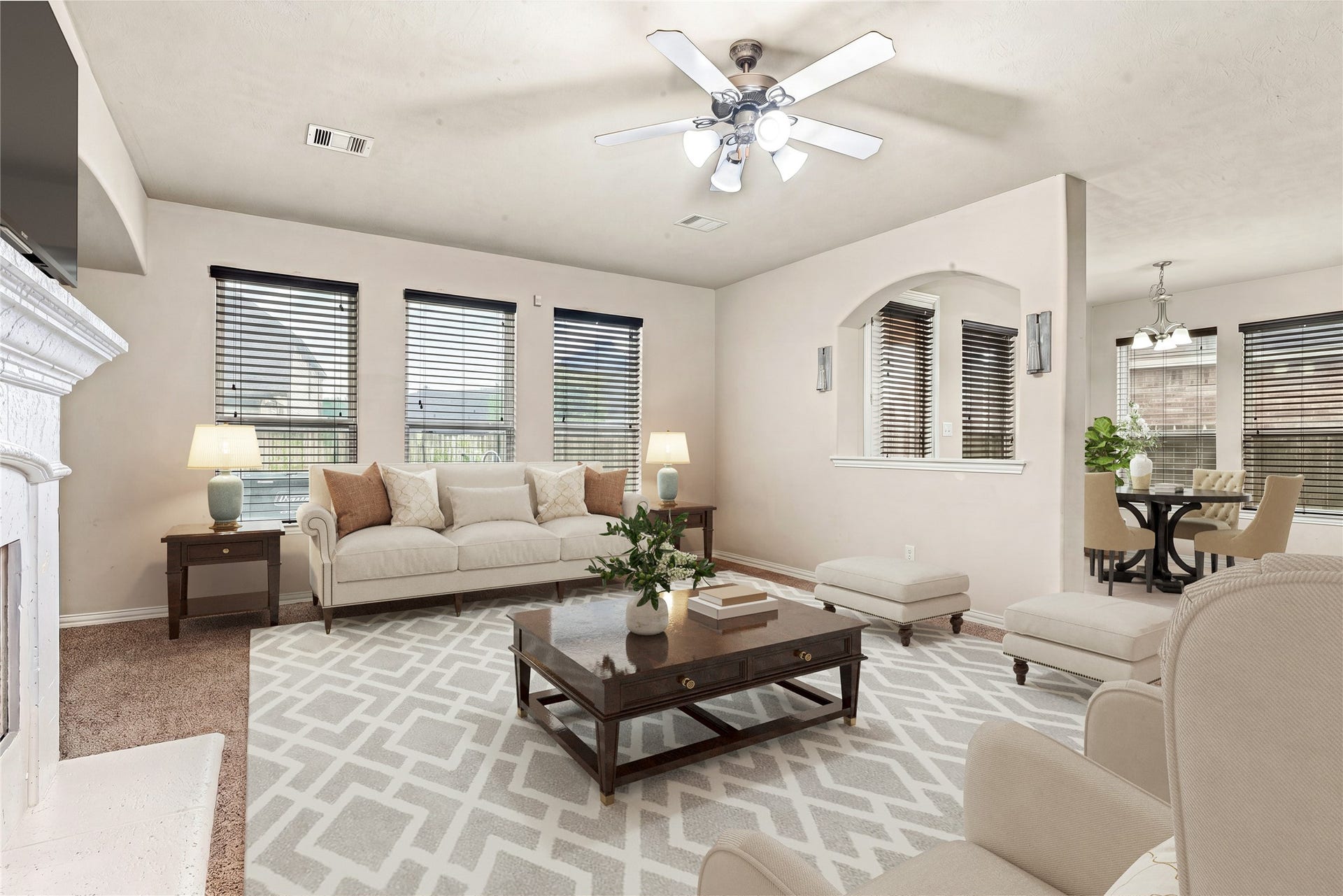 7018 Pearl Terrace Lane, Richmond, TX 77469 Spacious, light-filled living room with a wall of windows, a cozy fireplace, and an open flow into the breakfast and dining area, perfect for everyday living and entertaining. *Virtually Staged