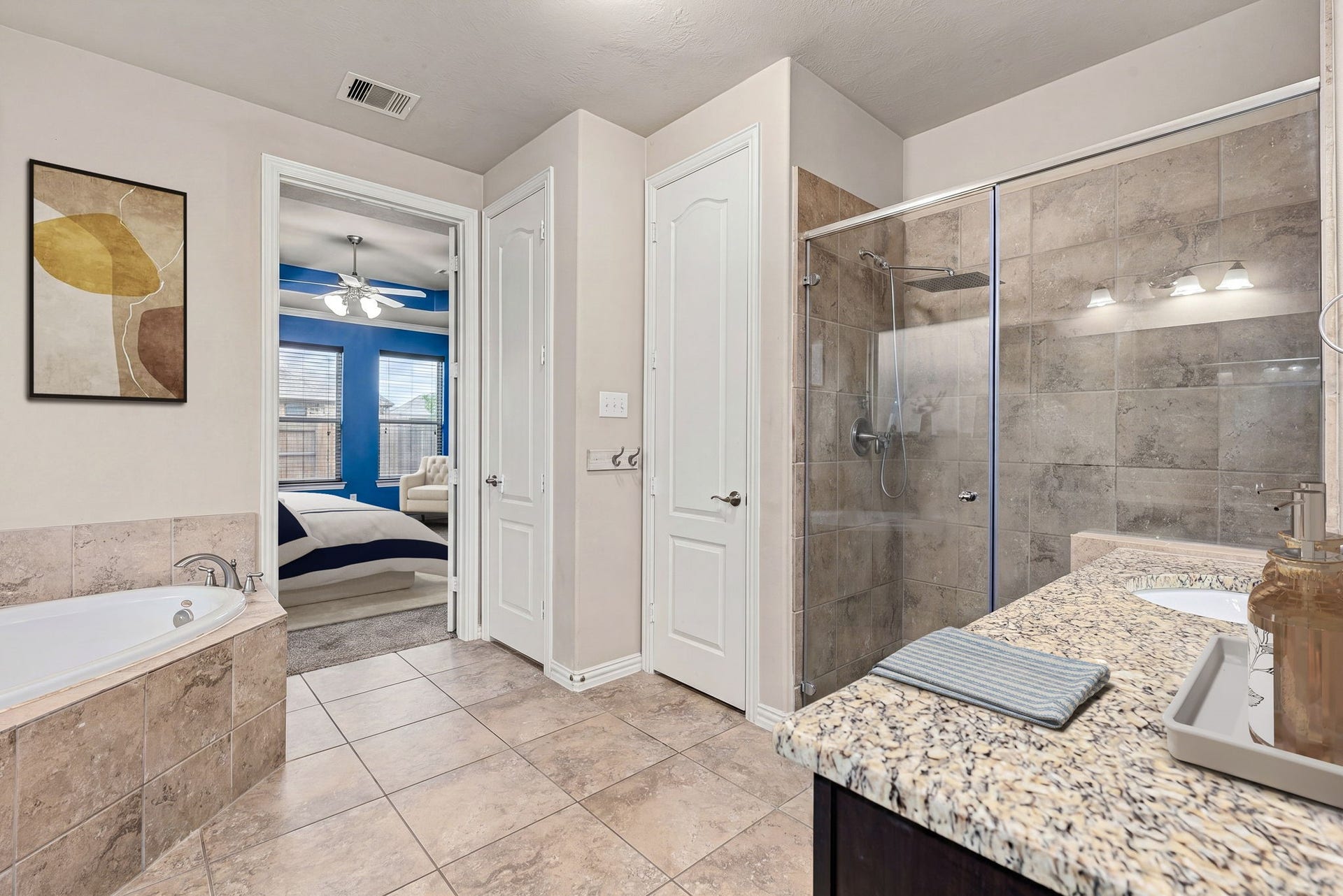 7018 Pearl Terrace Lane, Richmond, TX 77469 Spa-like primary bath with a soaking garden tub, a separate tile-surround walk-in shower, granite-topped vanity, and a private water closet, with direct access to the primary suite.