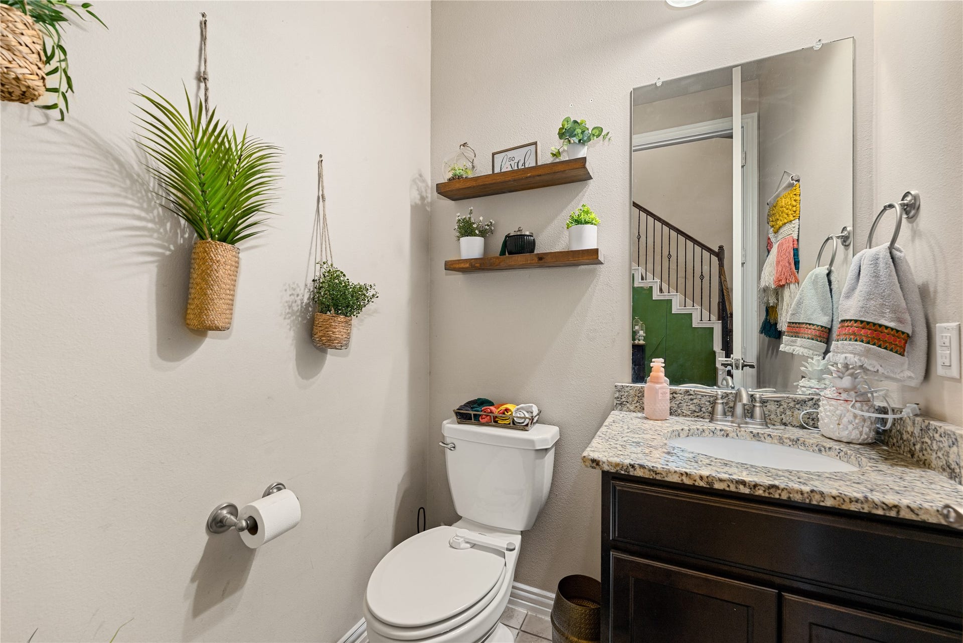 7018 Pearl Terrace Lane, Richmond, TX 77469 Convenient main-floor powder bath featuring a granite-topped vanity, large mirror, and tile flooring, a stylish, functional space for guests.