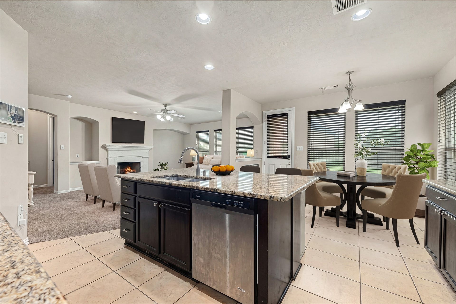 7018 Pearl Terrace Lane, Richmond, TX 77469 A true entertainer's layout, the granite island and bar seating open to the living room with fireplace on one side and the formal dining room on the other. *Virtually Staged