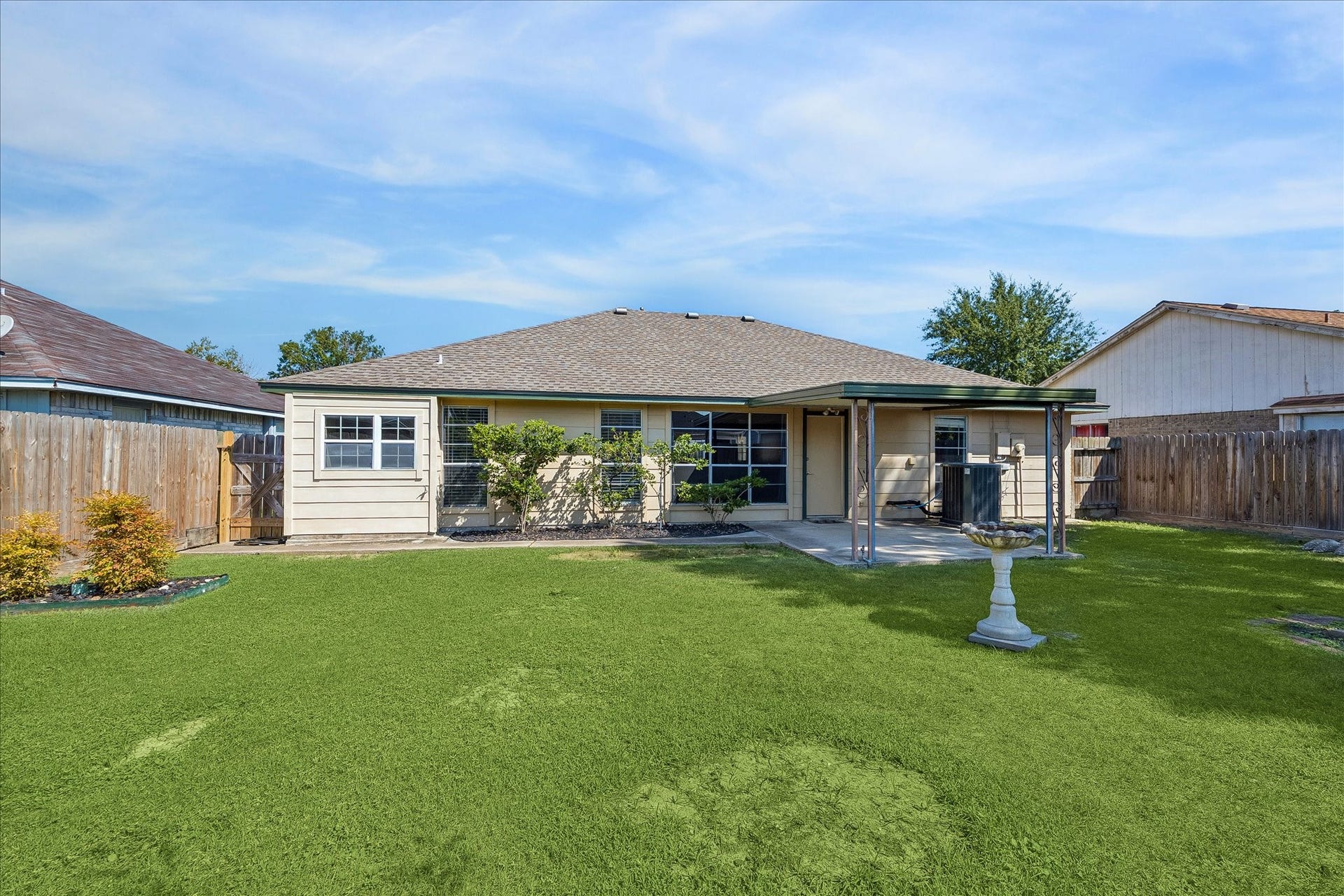 16911 Summer Dawn Place, Houston, TX 77095 Spacious fenced backyard offers an open stretch of lawn with the covered patio positioned just off the rear of the home.