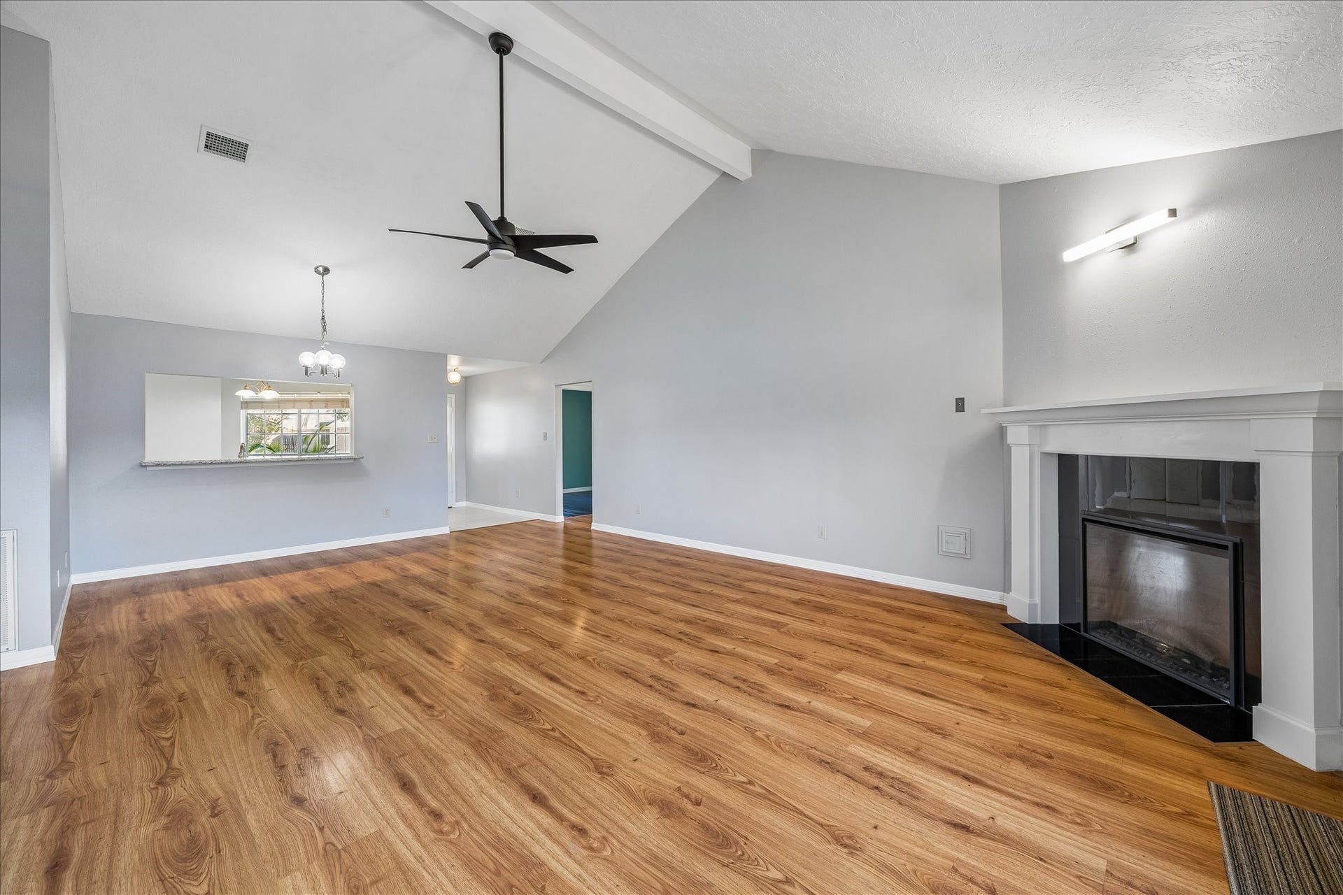 16911 Summer Dawn Place, Houston, TX 77095 Vaulted ceilings and exposed beam detail bring extra volume to the living room, anchored by a remote-controlled electric fireplace and LED accent light installed in 2023.