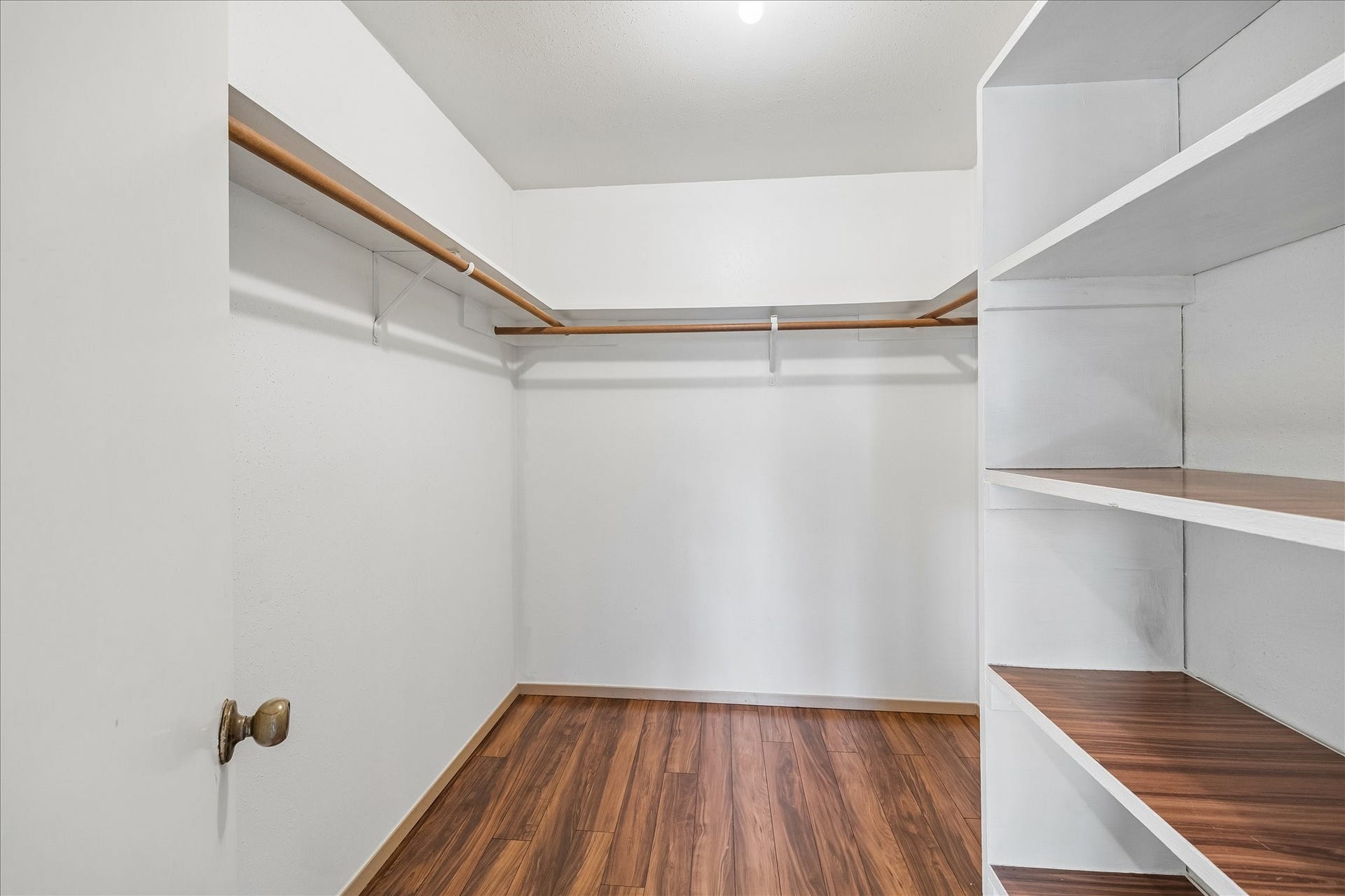 16911 Summer Dawn Place, Houston, TX 77095 Walk-in primary closet is lined with wraparound hanging space and built-in shelving, keeping clothing and accessories neatly organized.