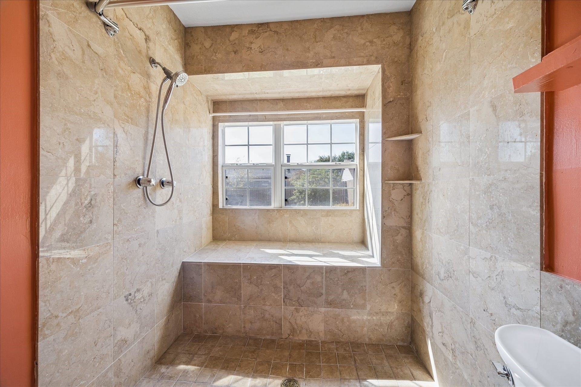 16911 Summer Dawn Place, Houston, TX 77095 Generously sized tiled shower features a handheld fixture, built-in ledge, and window that brings natural light into the primary bath.