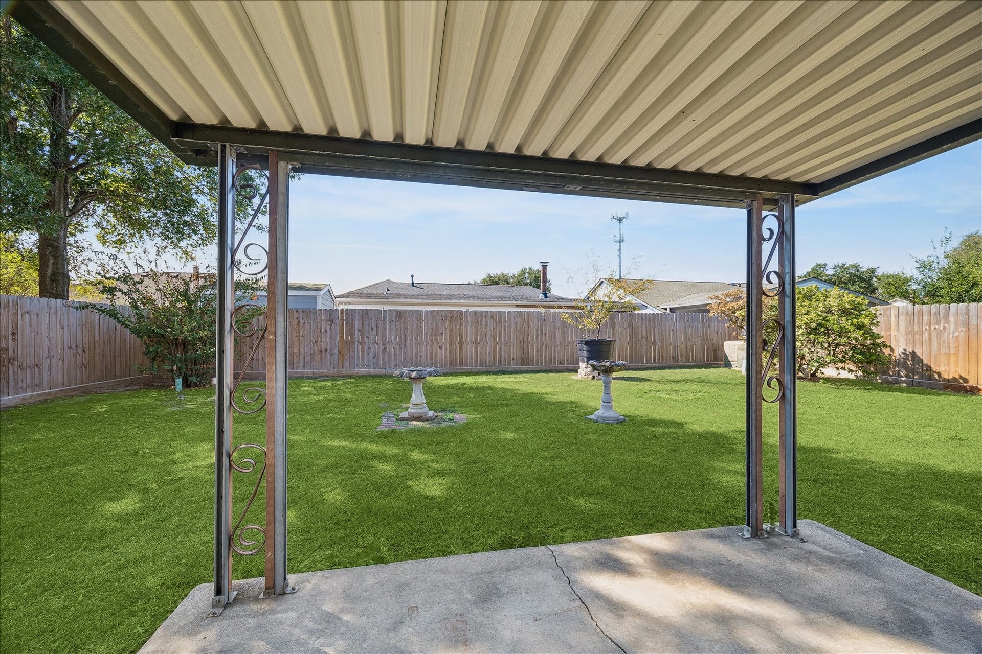 16911 Summer Dawn Place, Houston, TX 77095 Covered back patio creates a shaded outdoor spot for grilling, dining, or relaxing while looking out across the fenced yard.