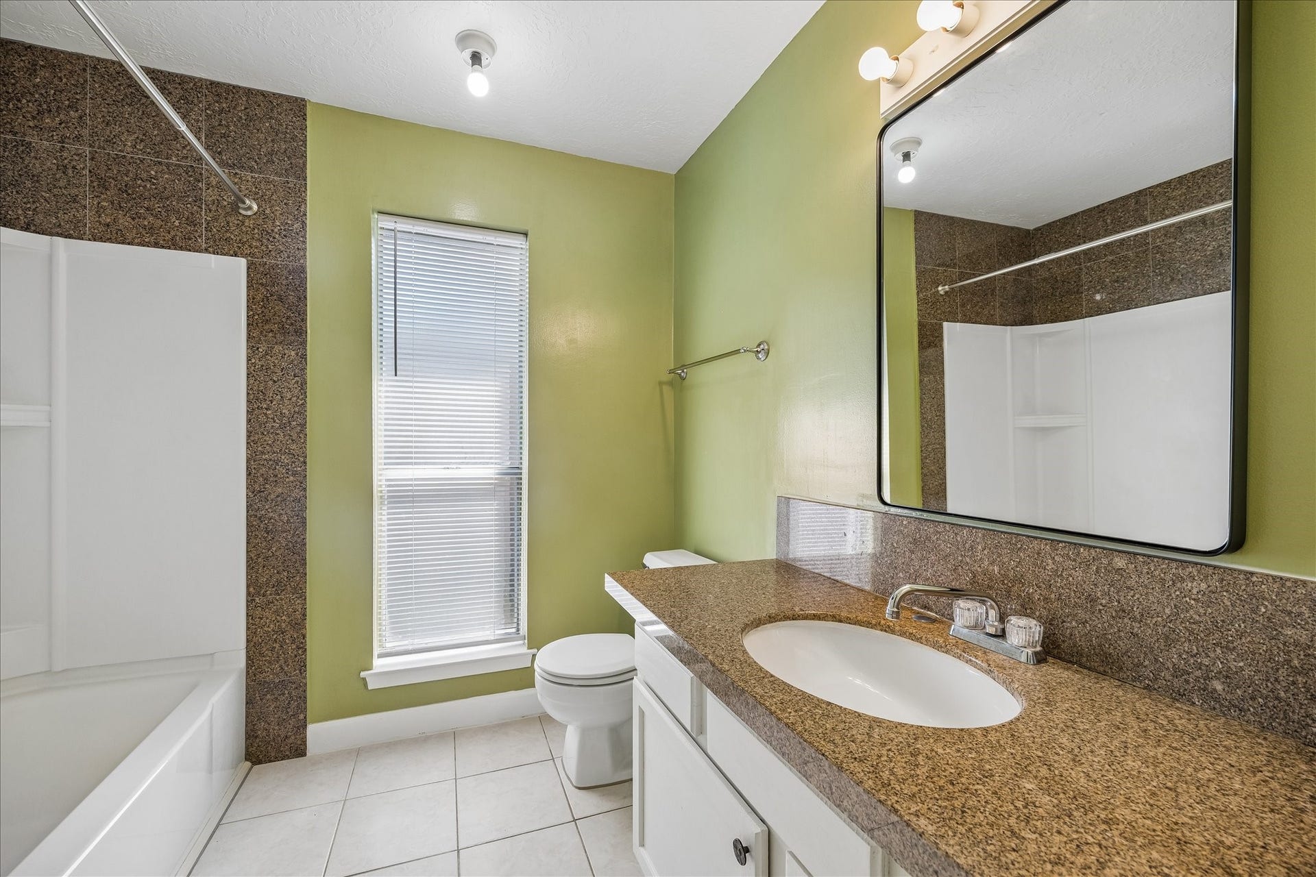 16911 Summer Dawn Place, Houston, TX 77095 Guest bath features a tub and shower combination, broad vanity, and tall window for additional light.