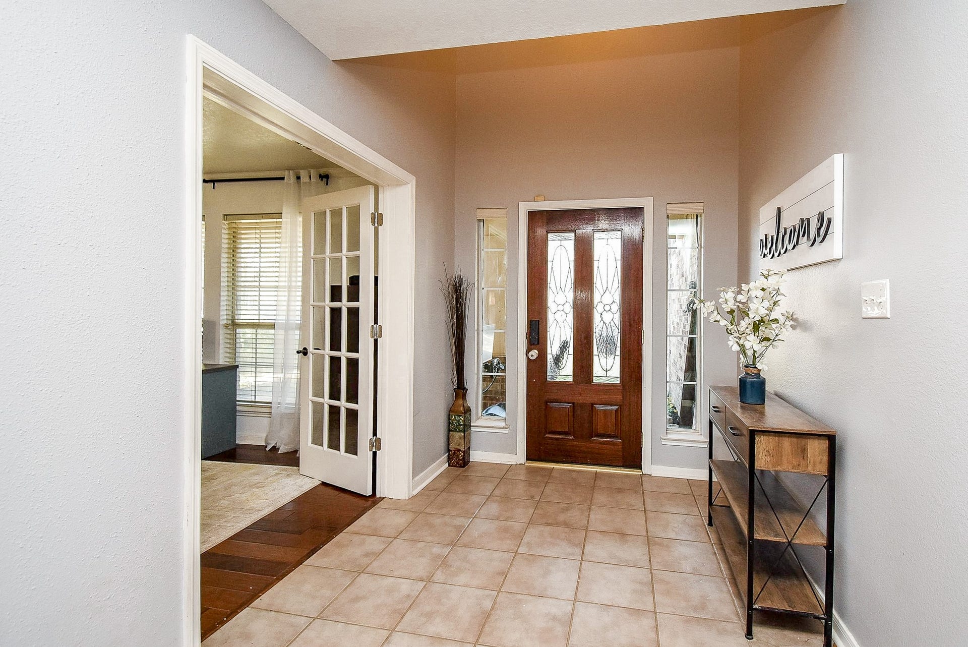 6703 Morning Glory Trace, Richmond, TX 77407 This inviting entryway features a wooden front door with decorative glass panels, flanked by side windows for natural light.