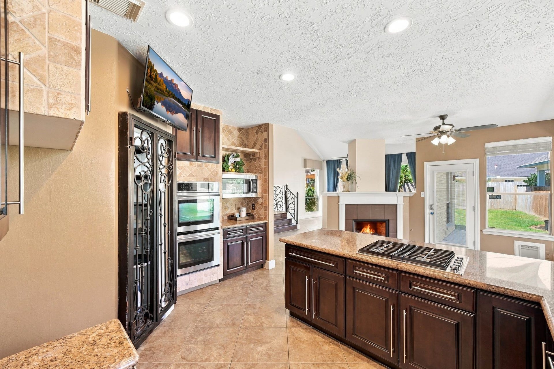 201 Lago Vista Street, League City, TX 77565 Create culinary masterpieces in this kitchen equipped with a double oven and expansive gas cooktop, all while enjoying the warmth of a cozy fireplace and abundant natural light.