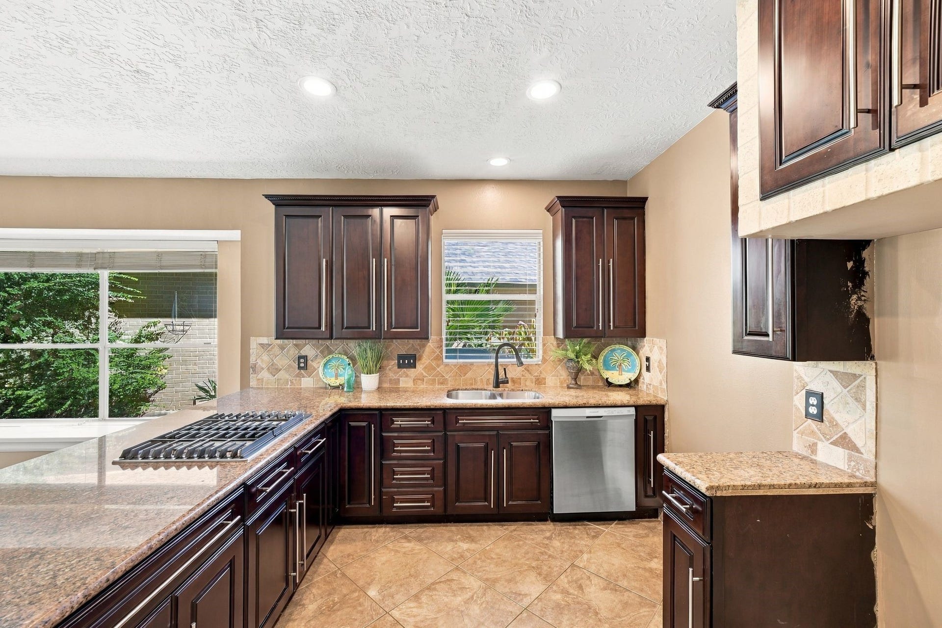 201 Lago Vista Street, League City, TX 77565 Discover a kitchen where elegance meets functionality, featuring rich dark wood cabinetry, sleek countertops, and abundant natural light for a warm, inviting atmosphere.