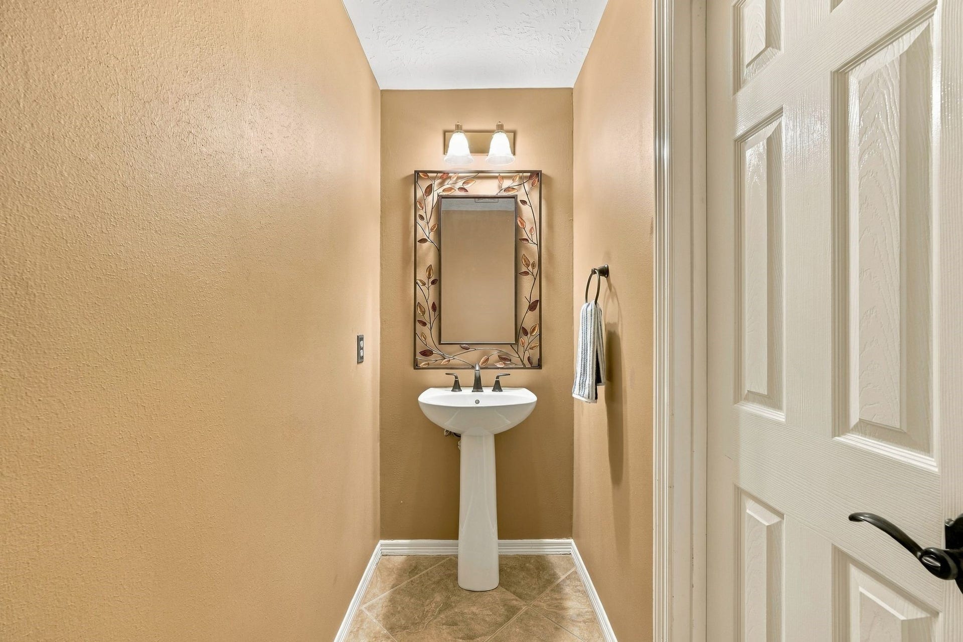 201 Lago Vista Street, League City, TX 77565 Conveniently located on the first floor, this charming half bath features warm tones and elegant fixtures, offering both style and functionality for guests.