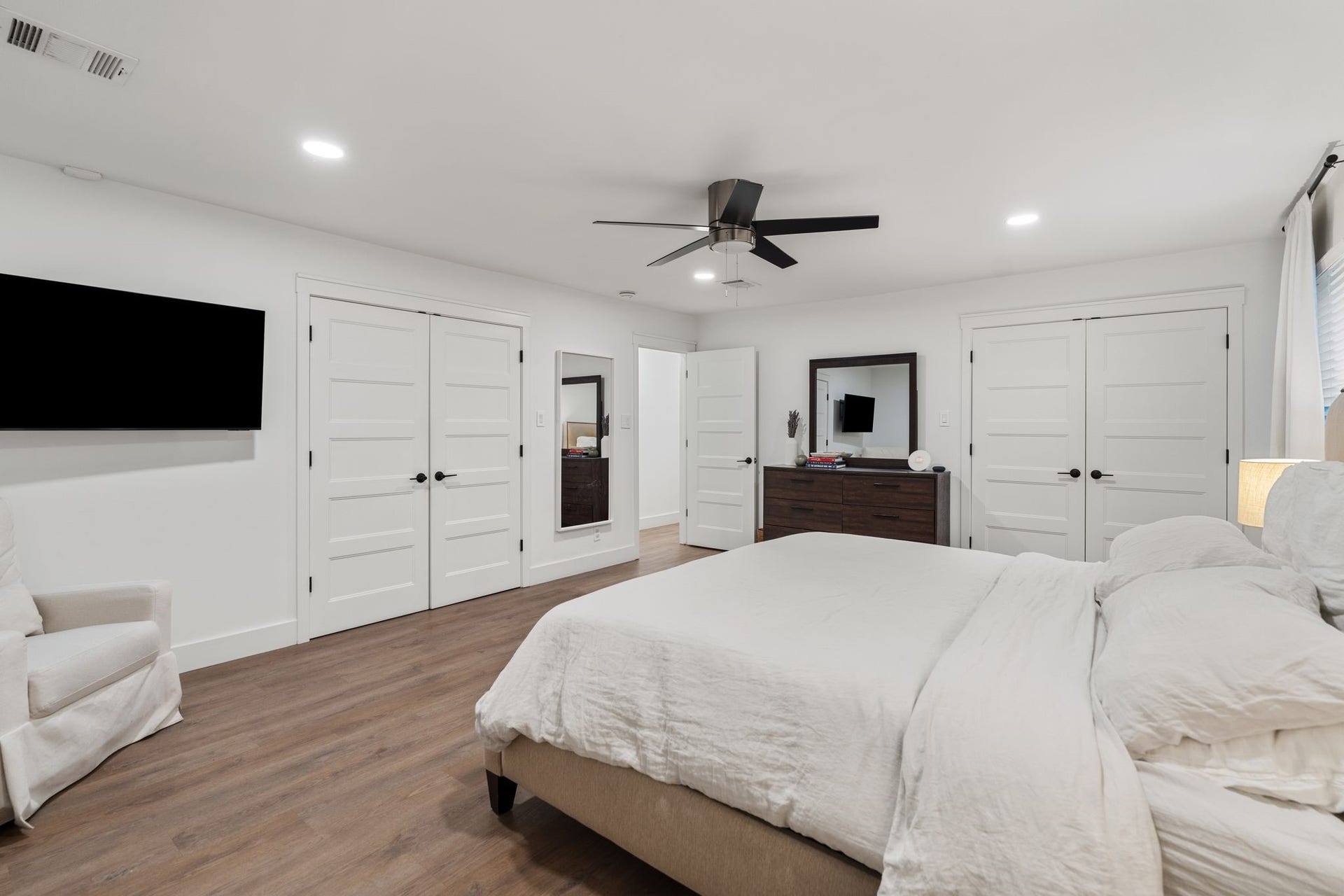 9206 Kapri Lane, Houston, TX 77025 Spacious primary bedroom features updated flooring, recessed lighting, a contemporary ceiling fan and multiple closets providing generous storage.