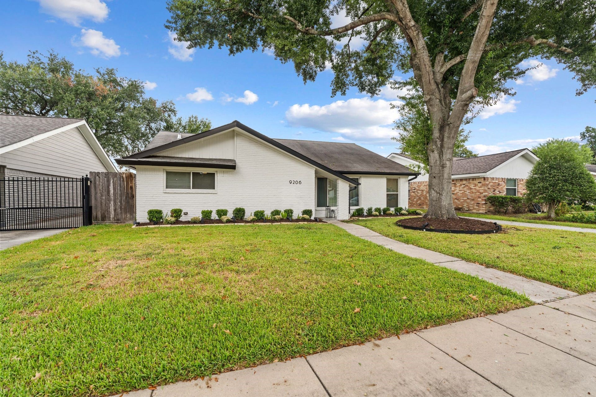 9206 Kapri Lane, Houston, TX 77025 Charming view of the home framed by a mature tree, landscaped beds and a welcoming walkway leading to the covered entry.