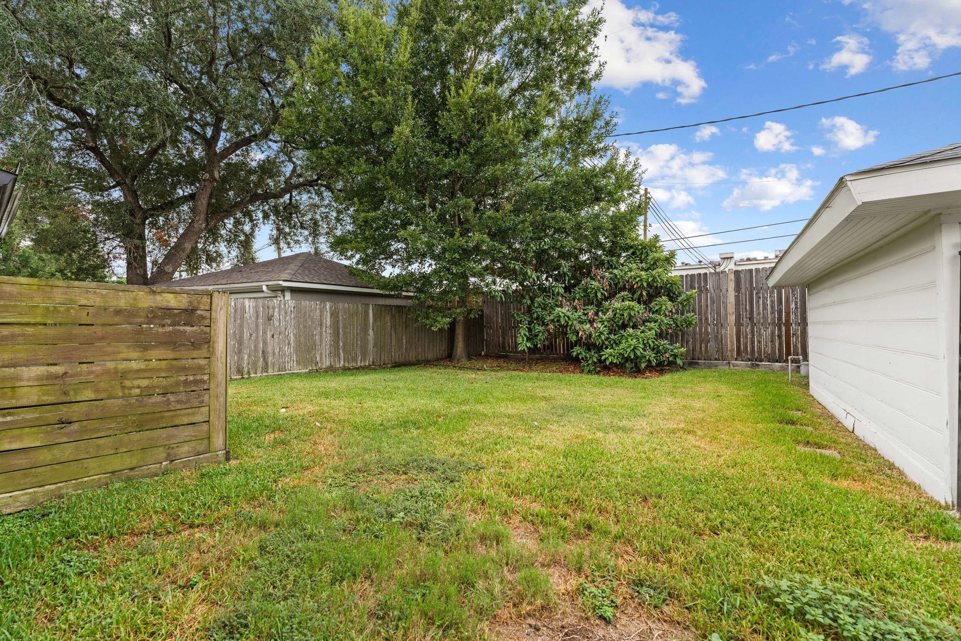 9206 Kapri Lane, Houston, TX 77025 Fully fenced backyard offers a generous lawn, mature trees and plenty of usable outdoor space, complemented by a detached garage.