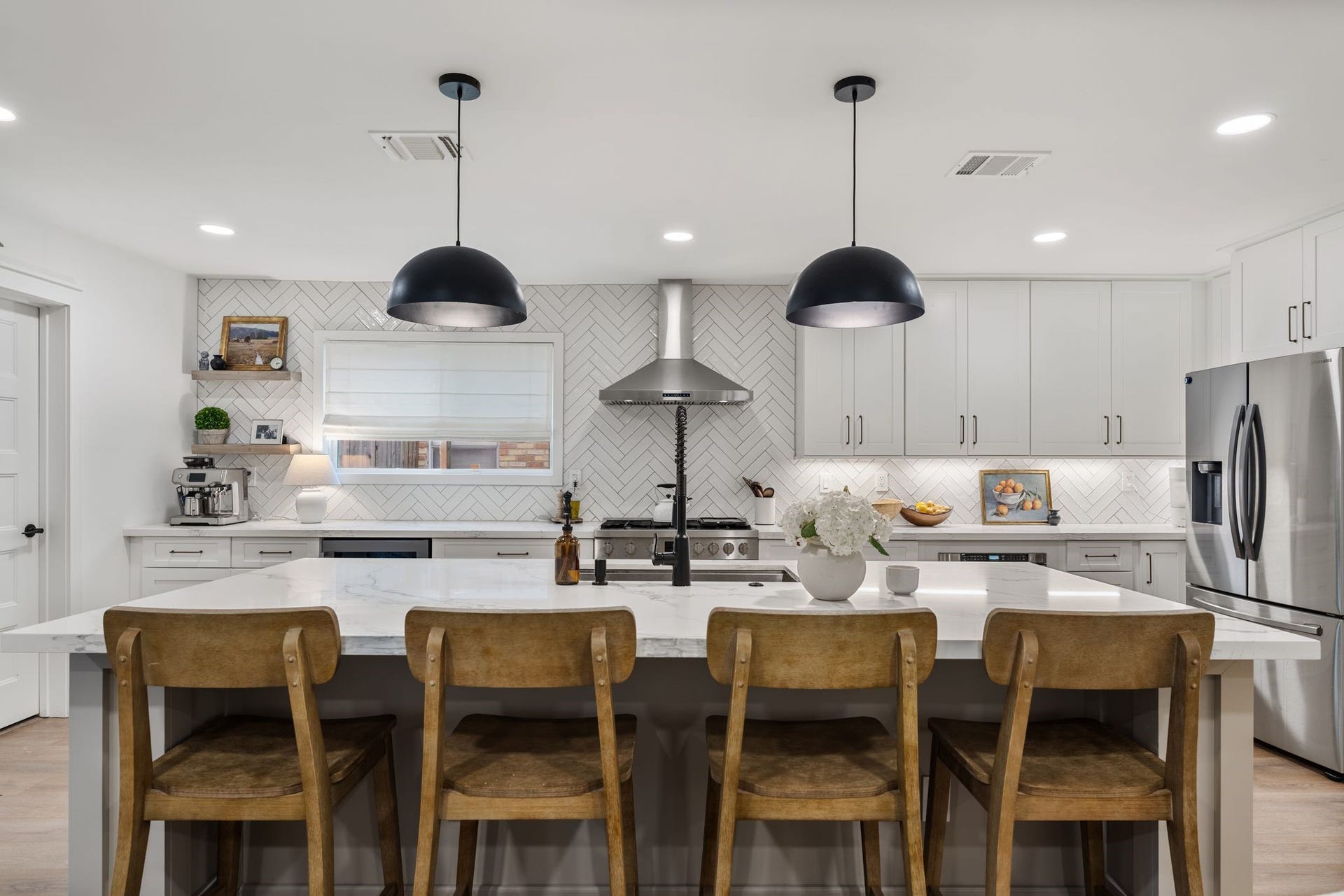 9206 Kapri Lane, Houston, TX 77025 Impressive oversized kitchen island provides expansive prep and gathering space, complemented by pendant lighting, an under-mount sink.