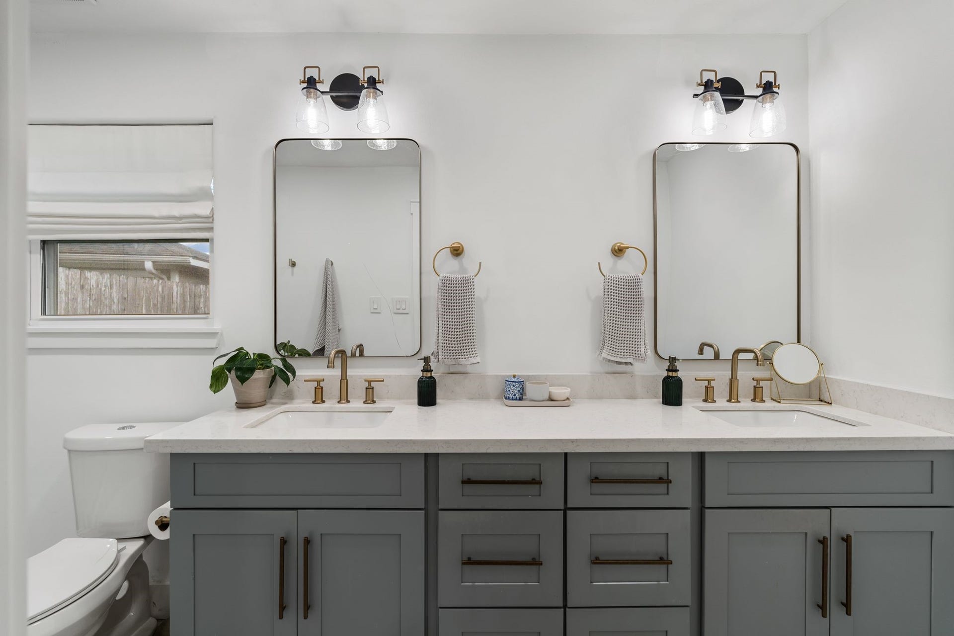 9206 Kapri Lane, Houston, TX 77025 The primary bath offers double vanity with abundant cabinetry, dual under-mount sinks, quartz-style counters, brushed-gold fixtures, individual mirrors and contemporary vanity lighting.