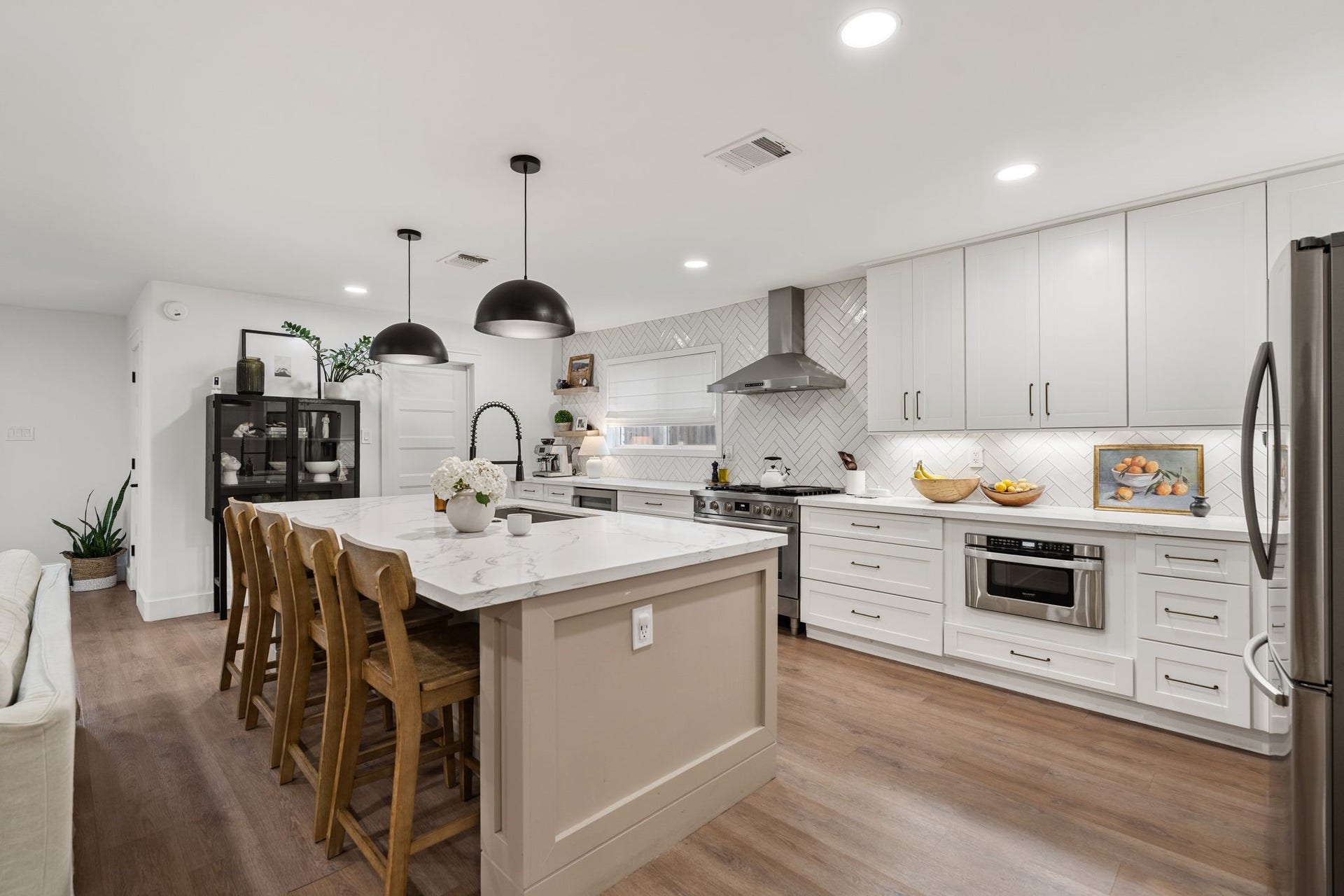 9206 Kapri Lane, Houston, TX 77025 Kitchen island with generous seating space. The kitchen also features a built-in-microwave and under-cabinet lighting.