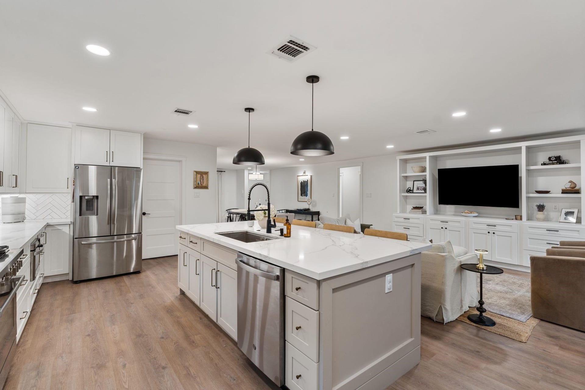 9206 Kapri Lane, Houston, TX 77025 The kitchen island provides expansive prep and gathering space, complemented by pendant lighting, an under-mount sink and extensive cabinetry.