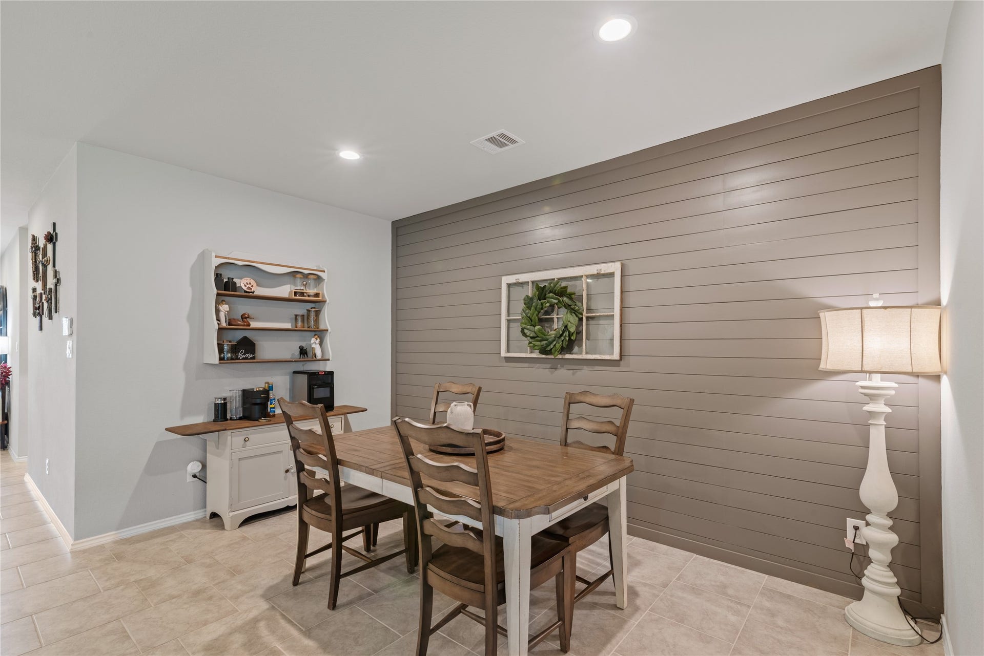 Charming dining area with a rustic shiplap accent wall, complemented by a cozy wooden table set and warm ambient lighting.