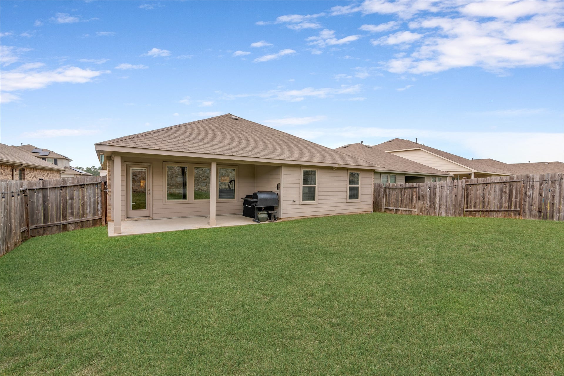 Spacious backyard with a covered patio, perfect for outdoor gatherings and relaxation.