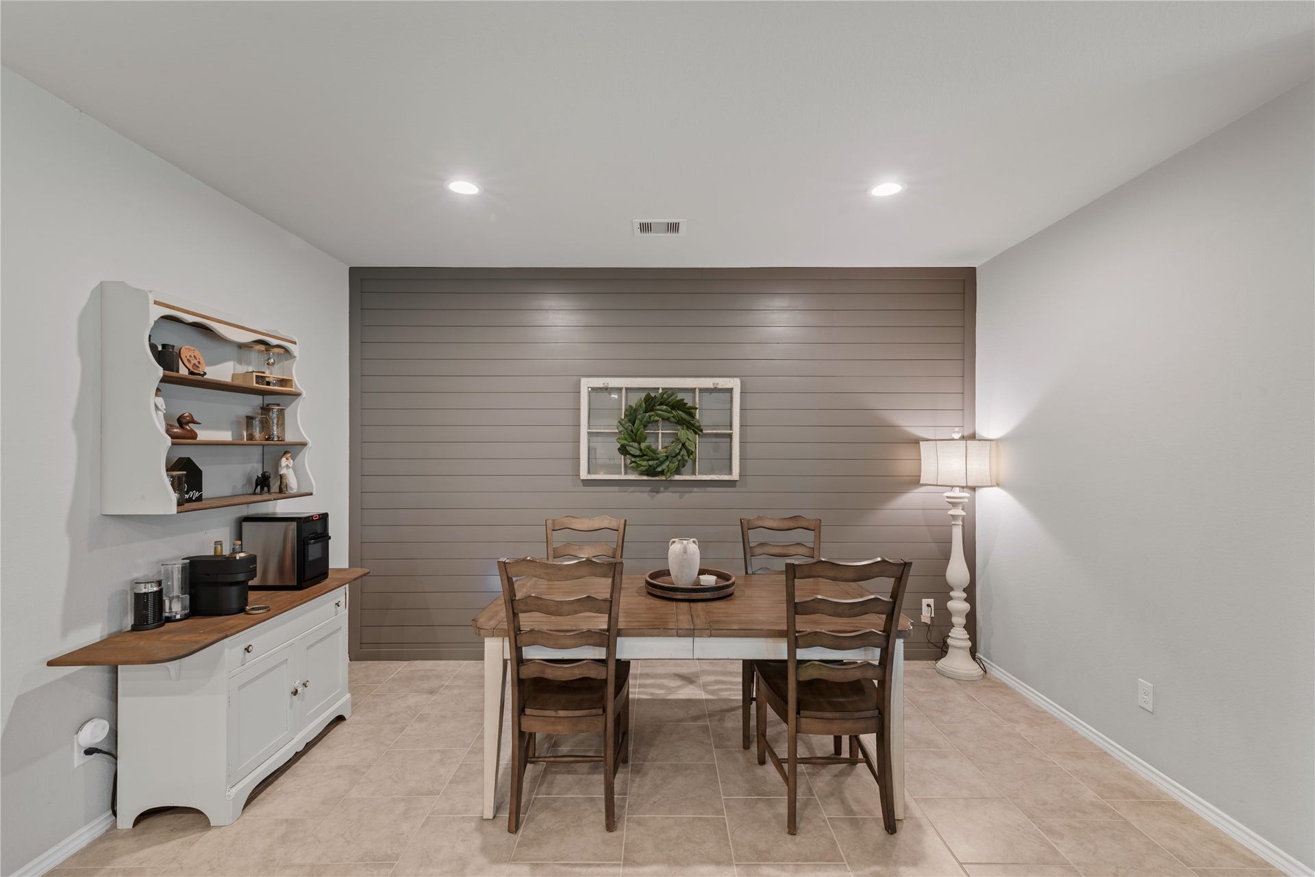 Charming dining area with a rustic wooden table, elegant shiplap accent wall, and warm ambient lighting, perfect for intimate gatherings.