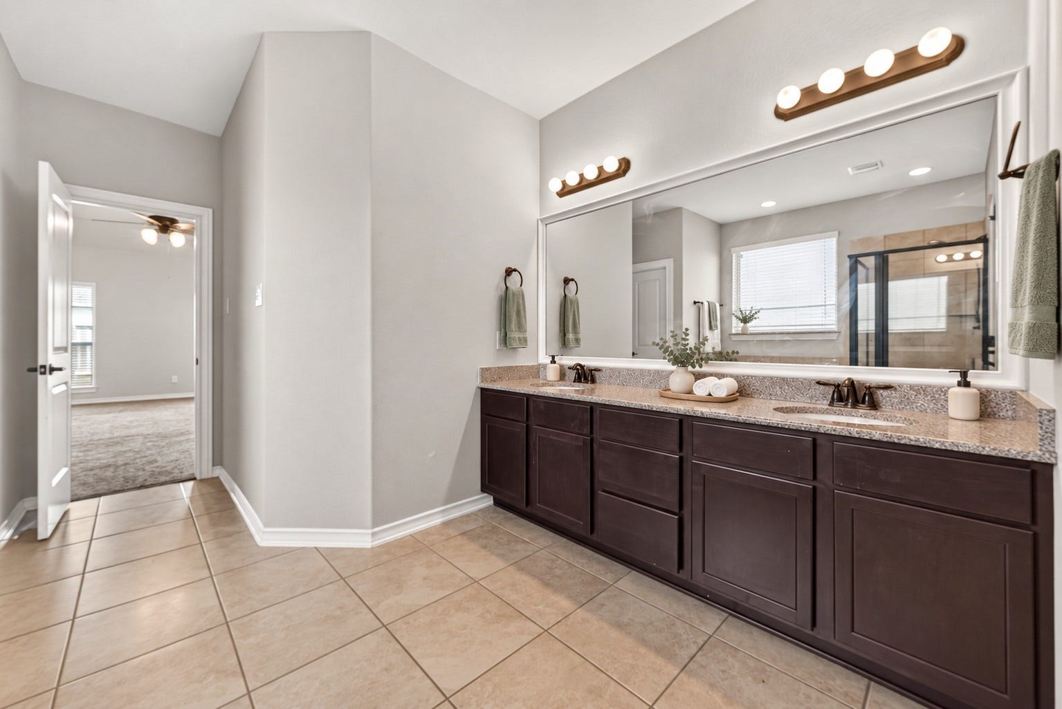 3658 Diamond Creek Drive, Missouri City, TX 77459 Primary bathroom features a long double-sinkvanity with generous counter and cabinet space.Large mirrors and overhead lighting brighten theroom.