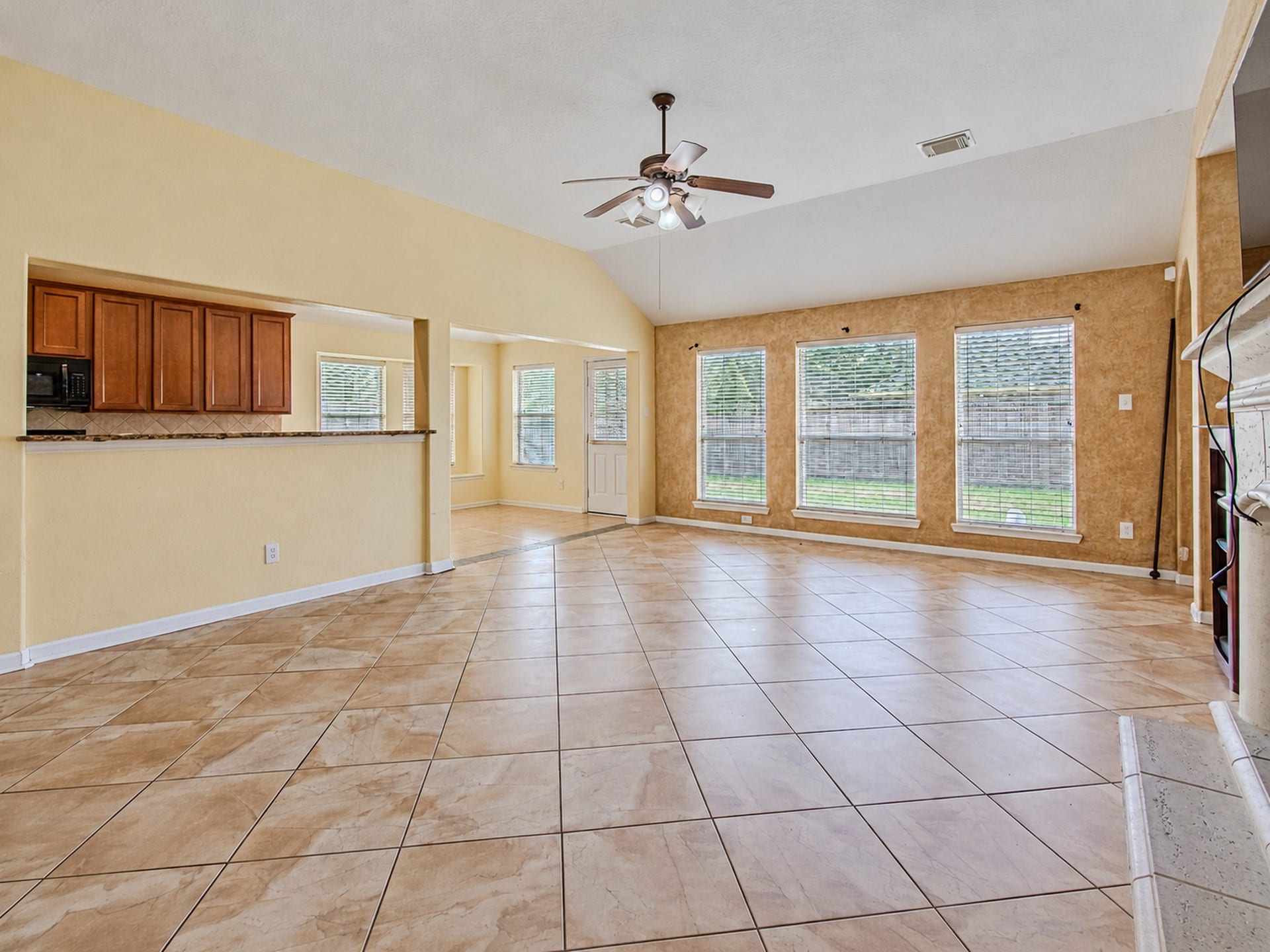 12906 Brook Arbor Court, Pearland, TX 77584 Large windows brighten the living room, with a breakfast bar connecting it to the kitchen