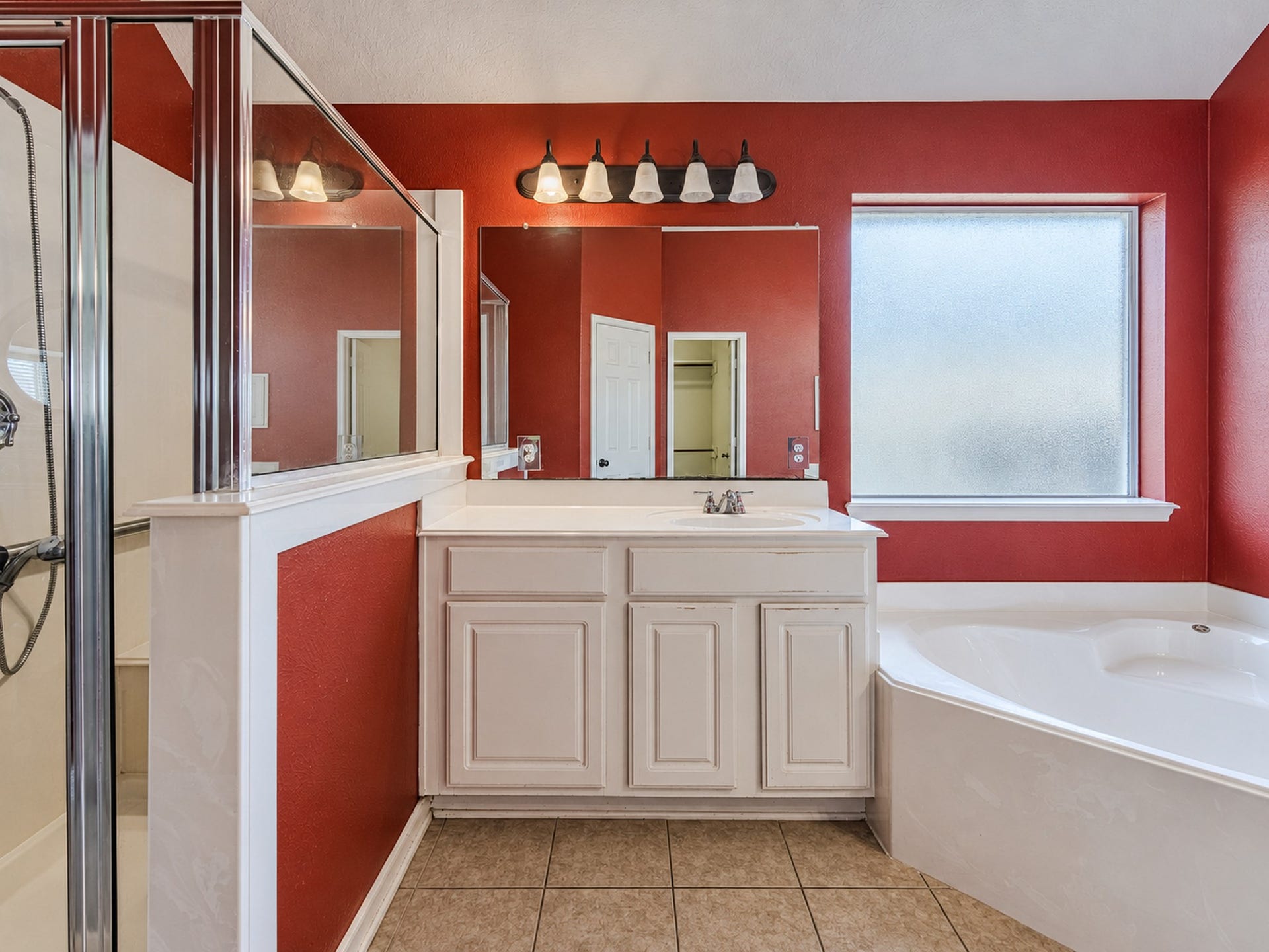 12906 Brook Arbor Court, Pearland, TX 77584 A closer look at the primary bath's shower, vanity storage, and window above the tub