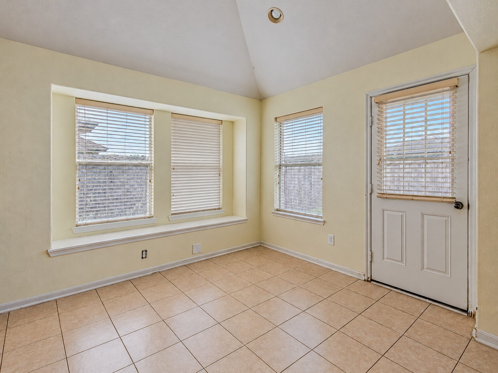 12906 Brook Arbor Court, Pearland, TX 77584 A bright breakfast nook features multiple windows and a door to the backyard