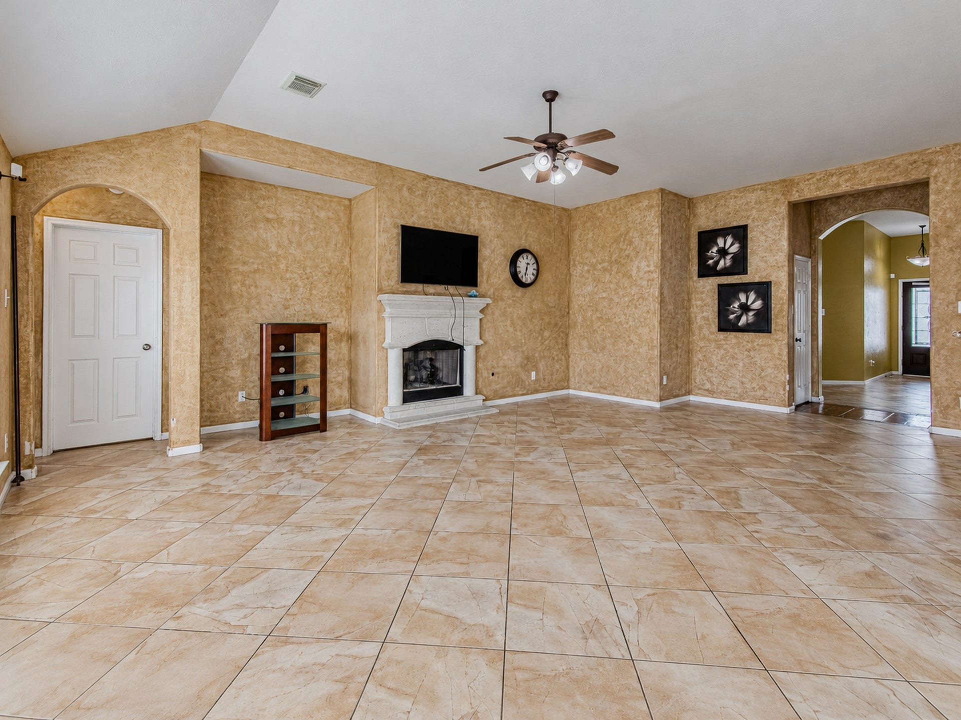 12906 Brook Arbor Court, Pearland, TX 77584 The spacious living room features tile flooring, a ceiling fan, and a fireplace