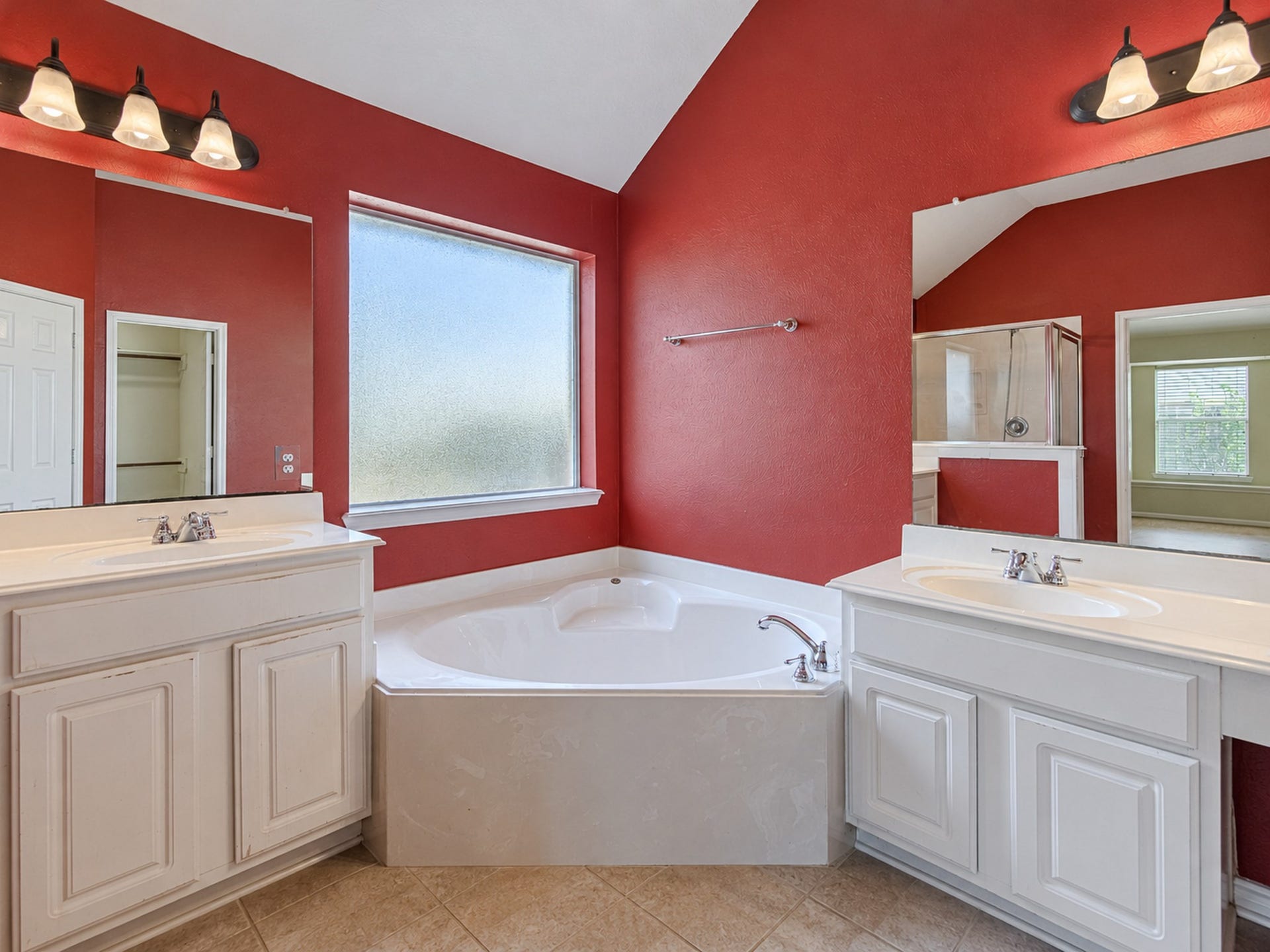 12906 Brook Arbor Court, Pearland, TX 77584 A corner soaking tub sits between two vanity areas in the primary bath