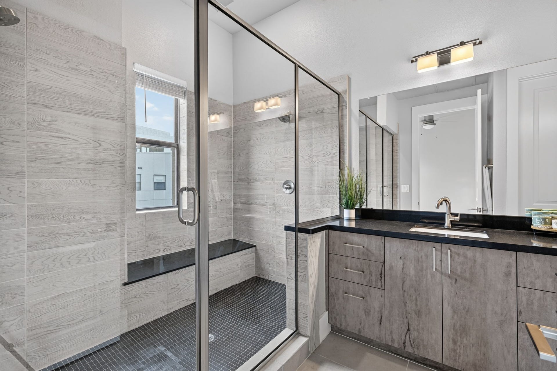 The primary bath features an oversized shower w/ bench, dual sinks, designer cabinets, commode and huge walk-in closet